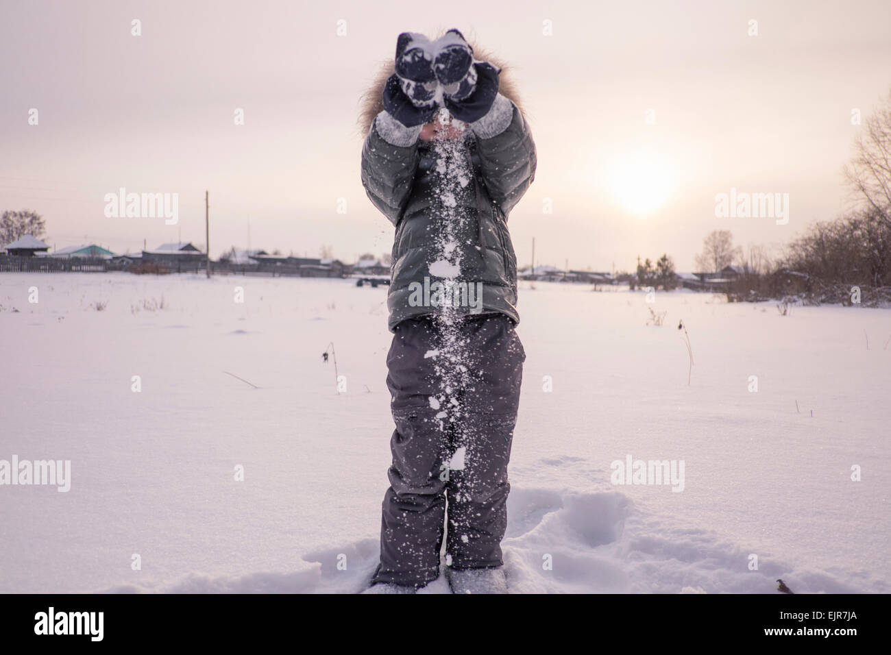 Mari boy in parka playing in snowy field Stock Photo
