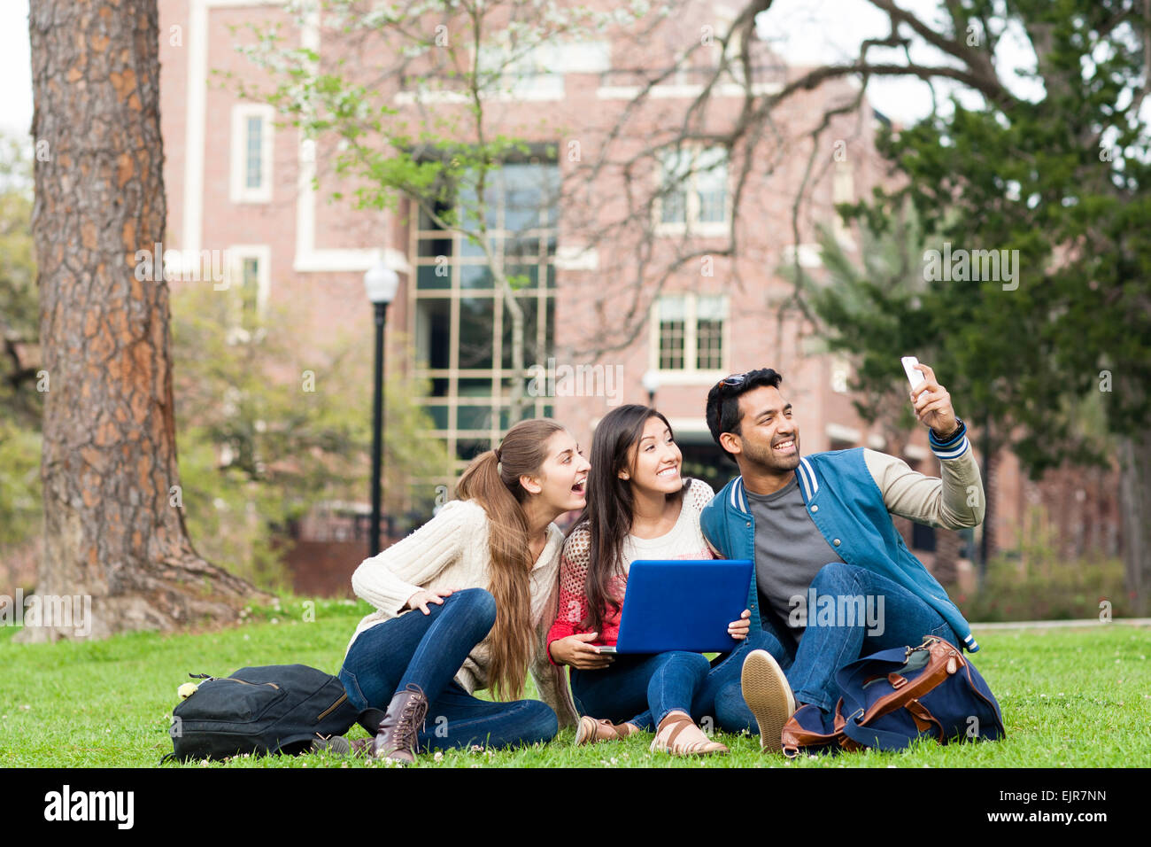 Students taking cell phone photograph on campus Stock Photo