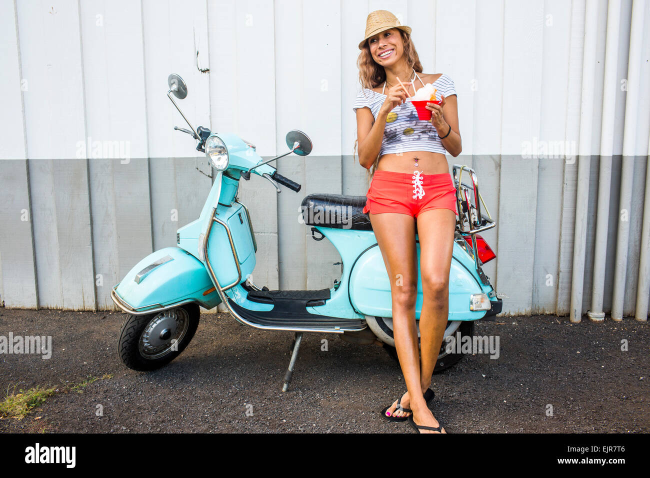 Woman eating shave ice near scooter Stock Photo