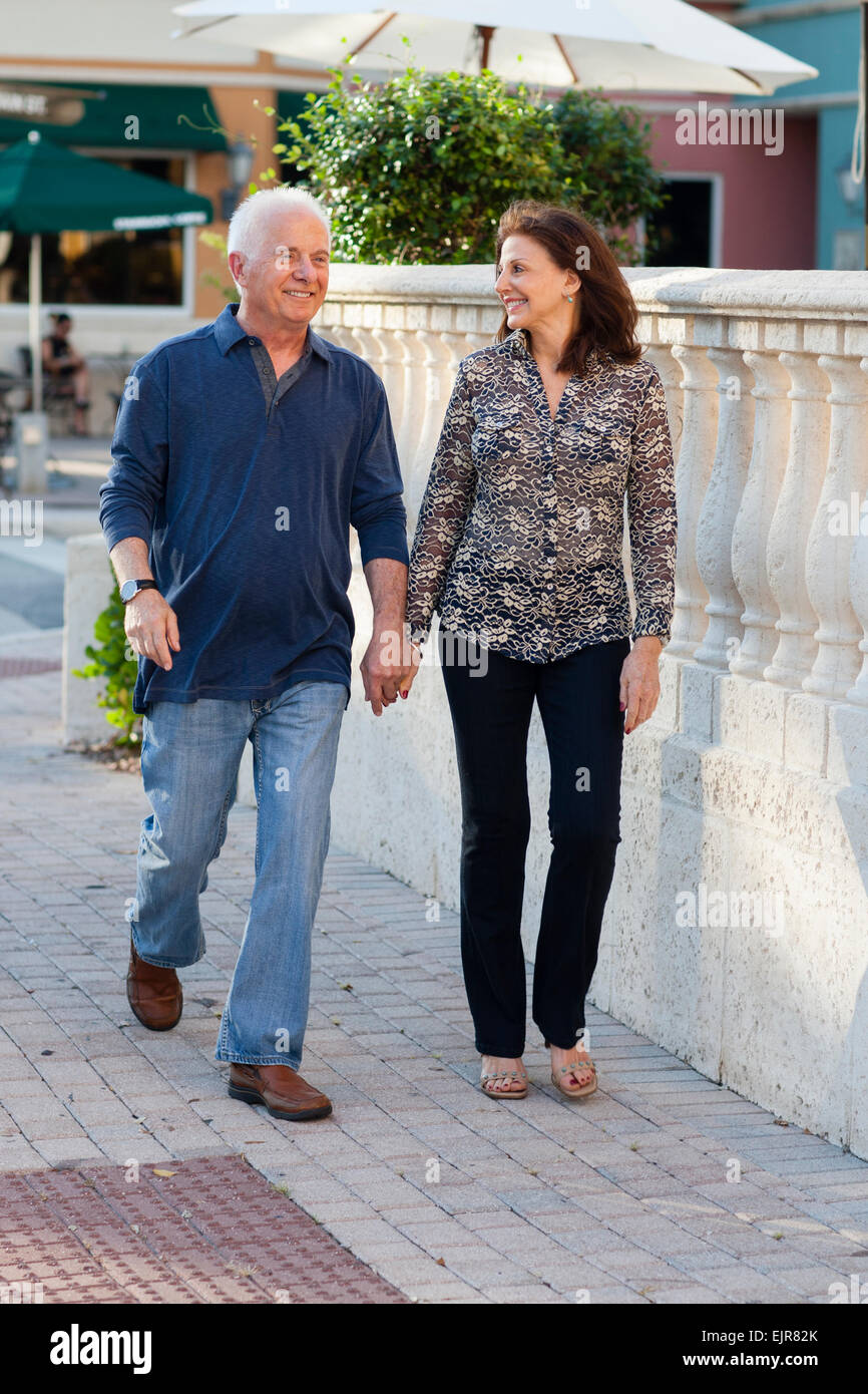 Older Caucasian couple holding hands on sidewalk Stock Photo