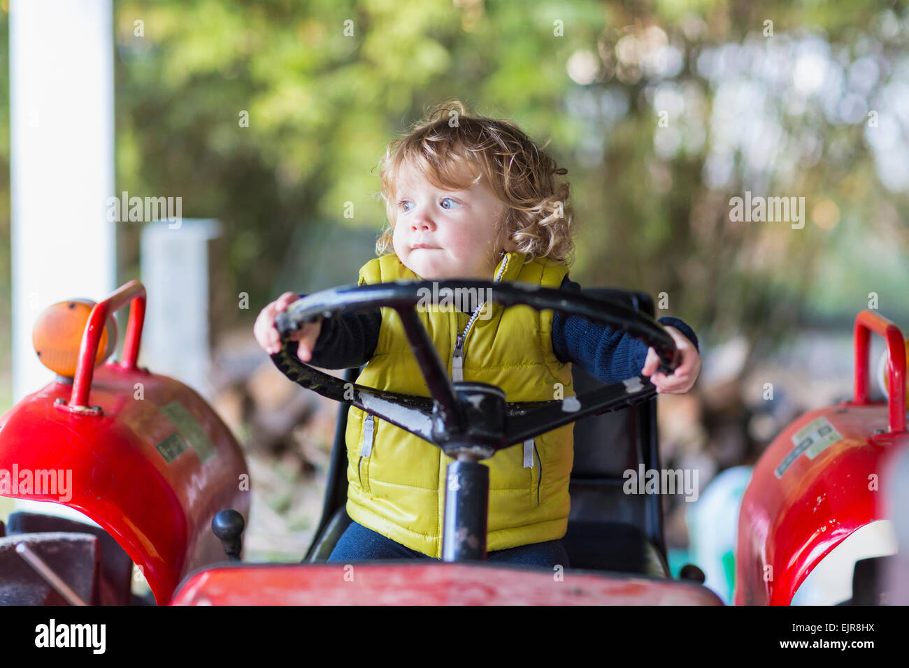 Caucasian baby boy driving tractor Stock Photo
