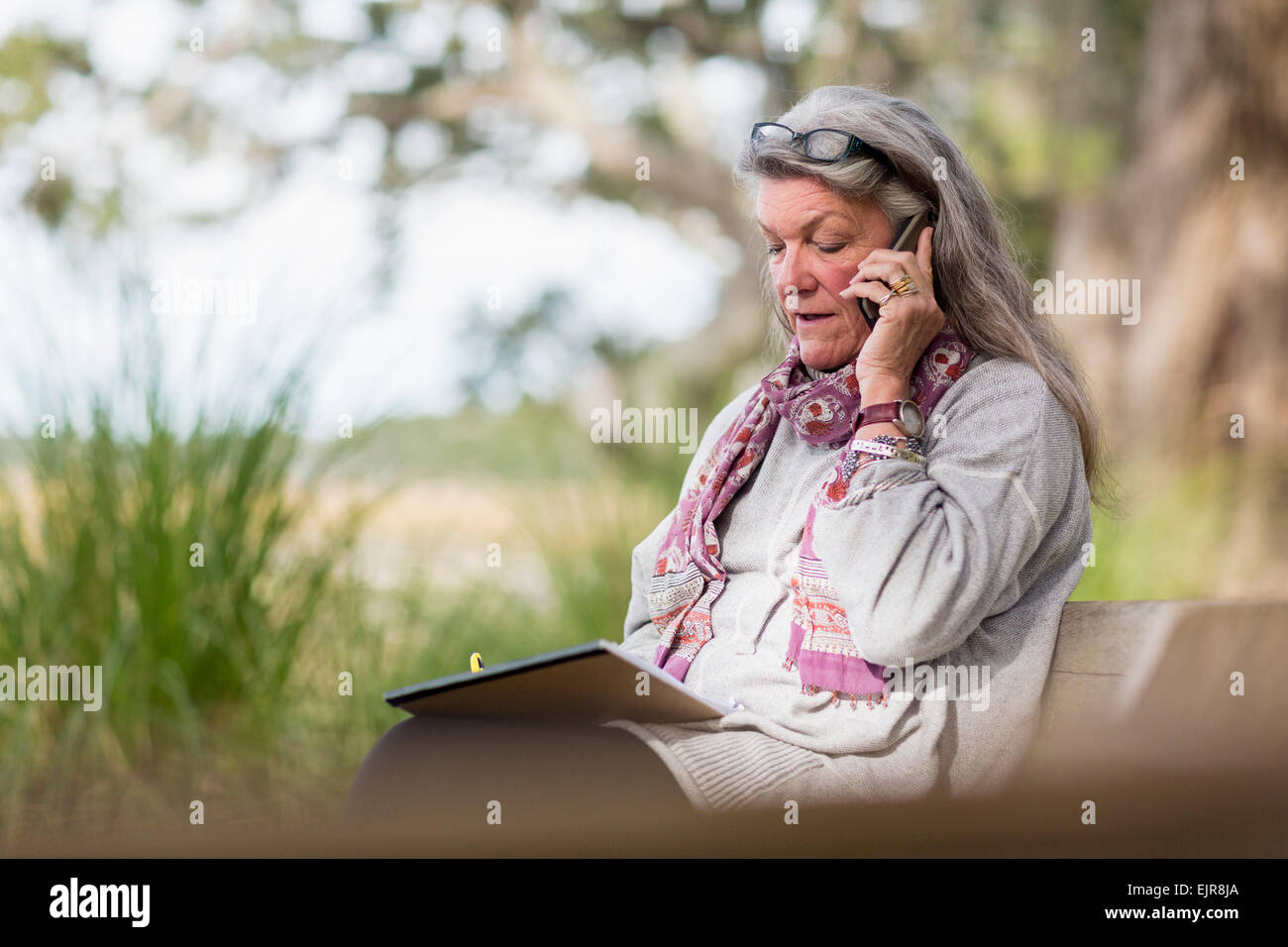 Older Caucasian woman talking on cell phone outdoors Stock Photo