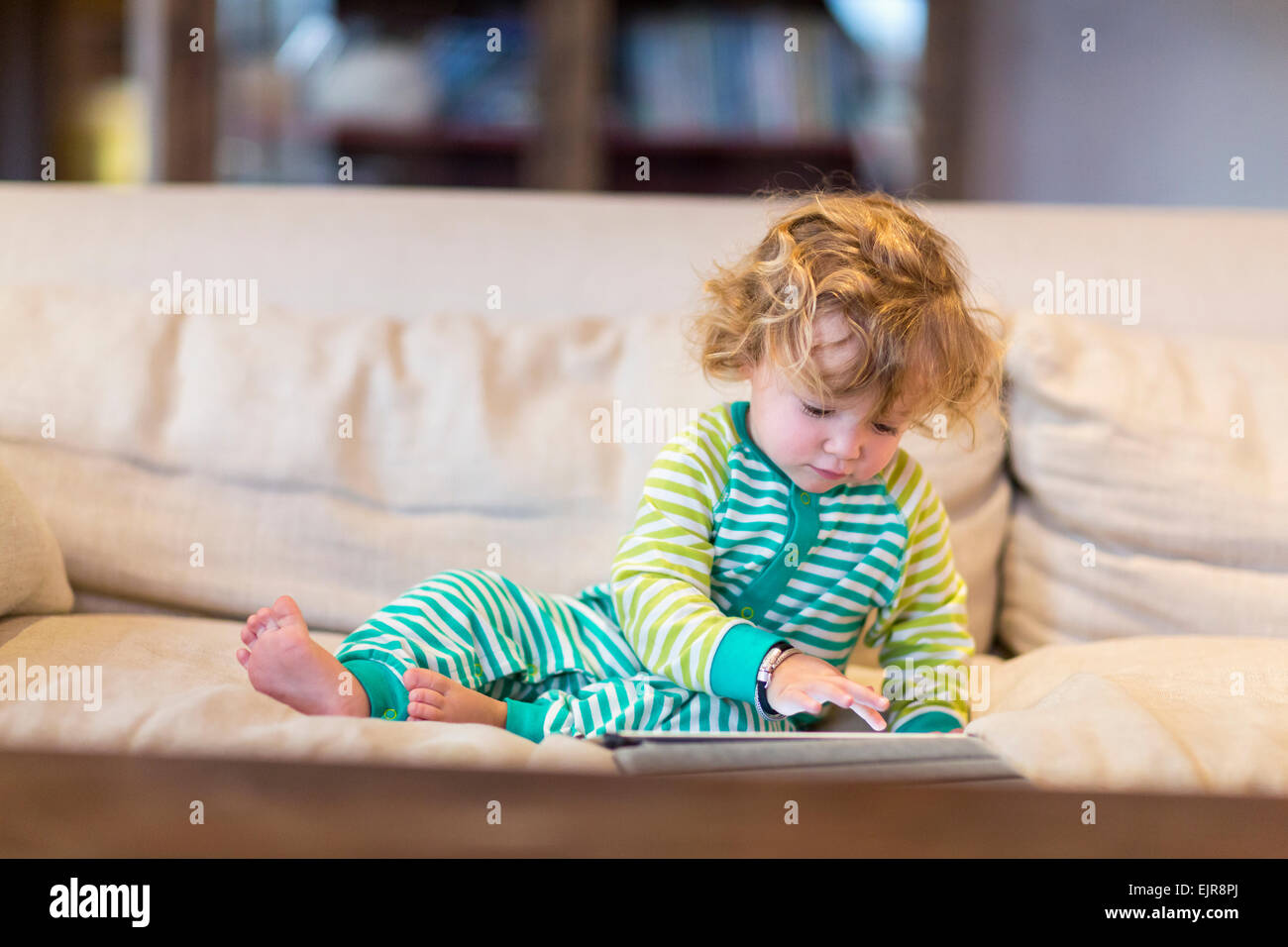 Caucasian baby boy using digital tablet on sofa Stock Photo