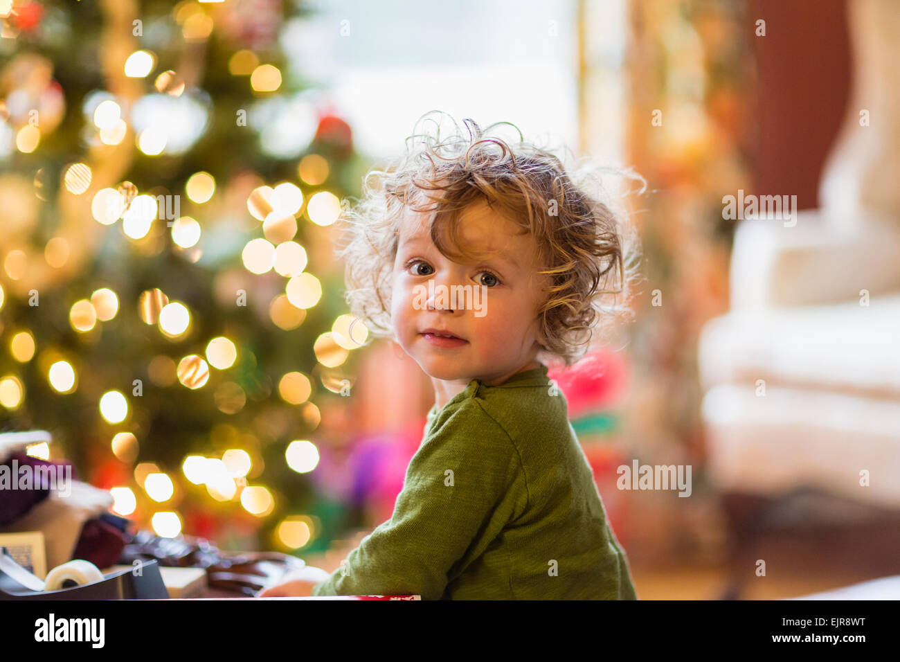 Caucasian baby boy sitting near Christmas tree Stock Photo