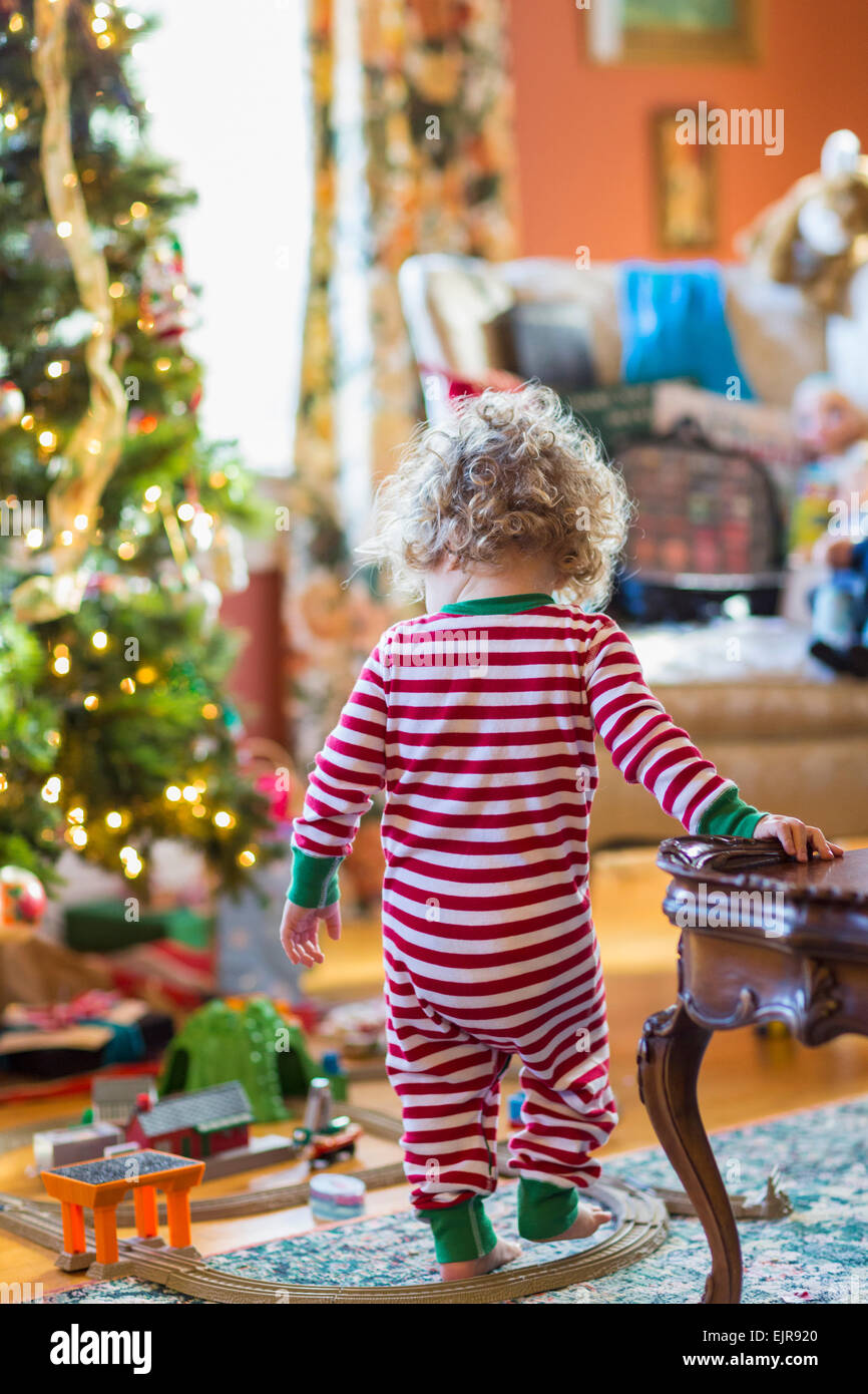 Caucasian baby boy playing with toys near Christmas tree Stock Photo