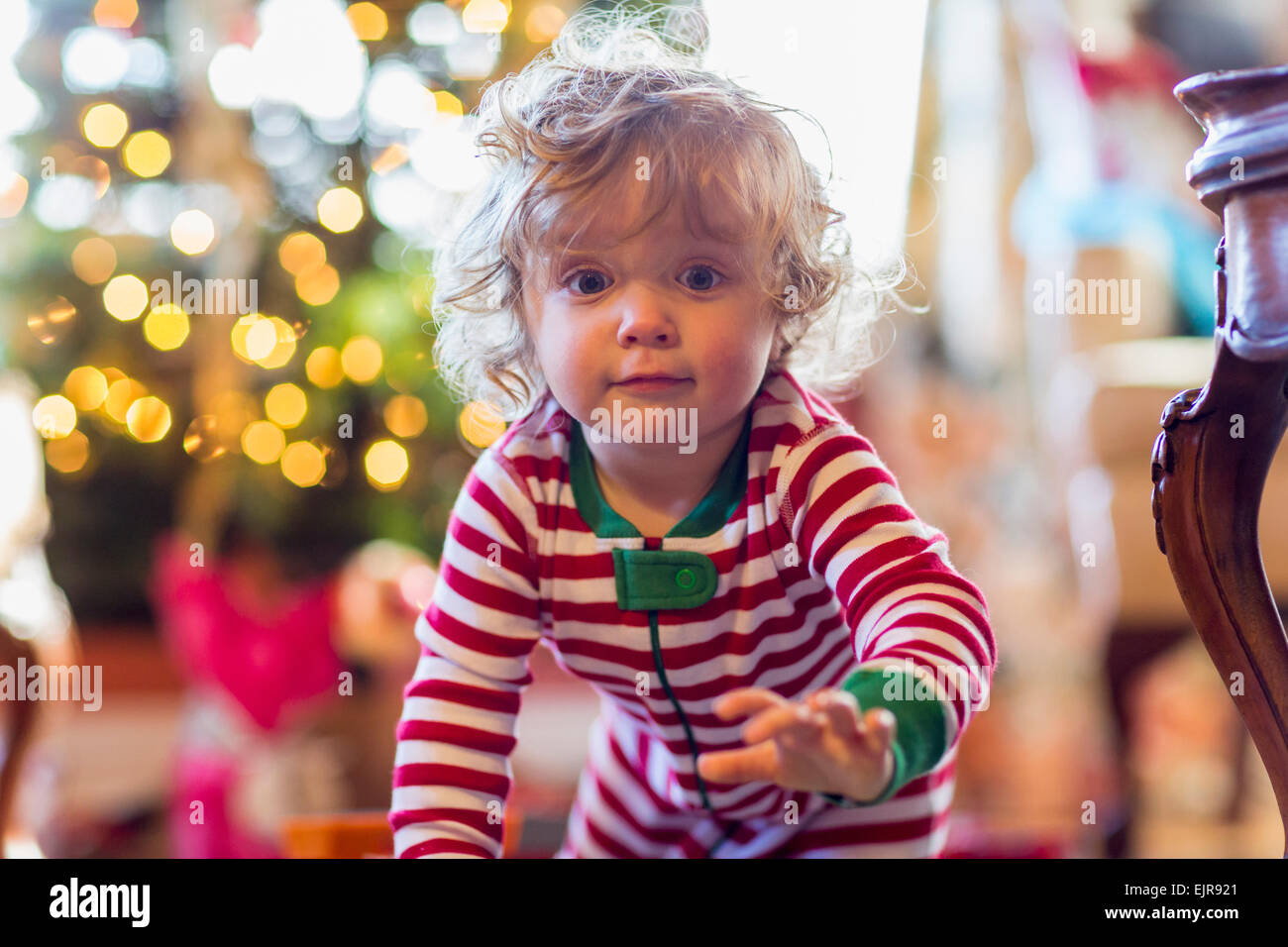 Caucasian baby boy crawling near Christmas tree Stock Photo
