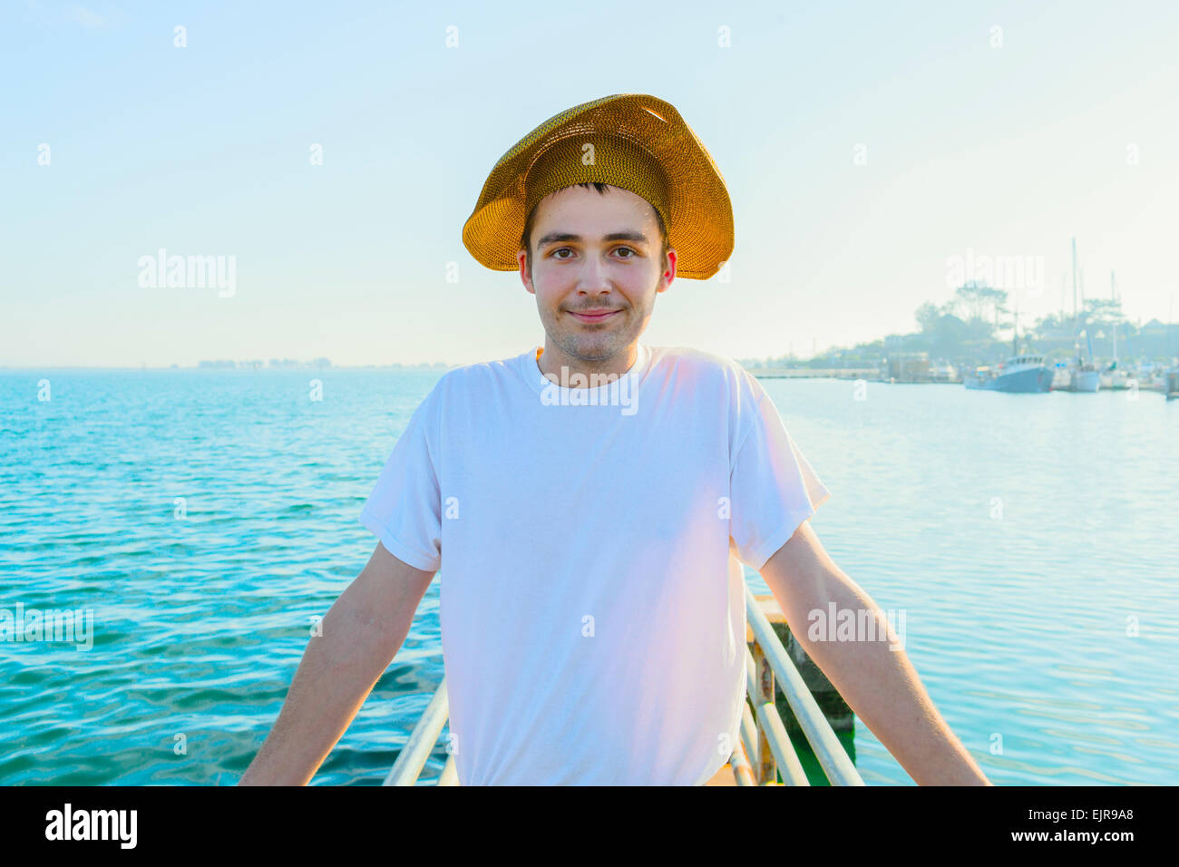 Caucasian man wearing sun hat on pier Stock Photo