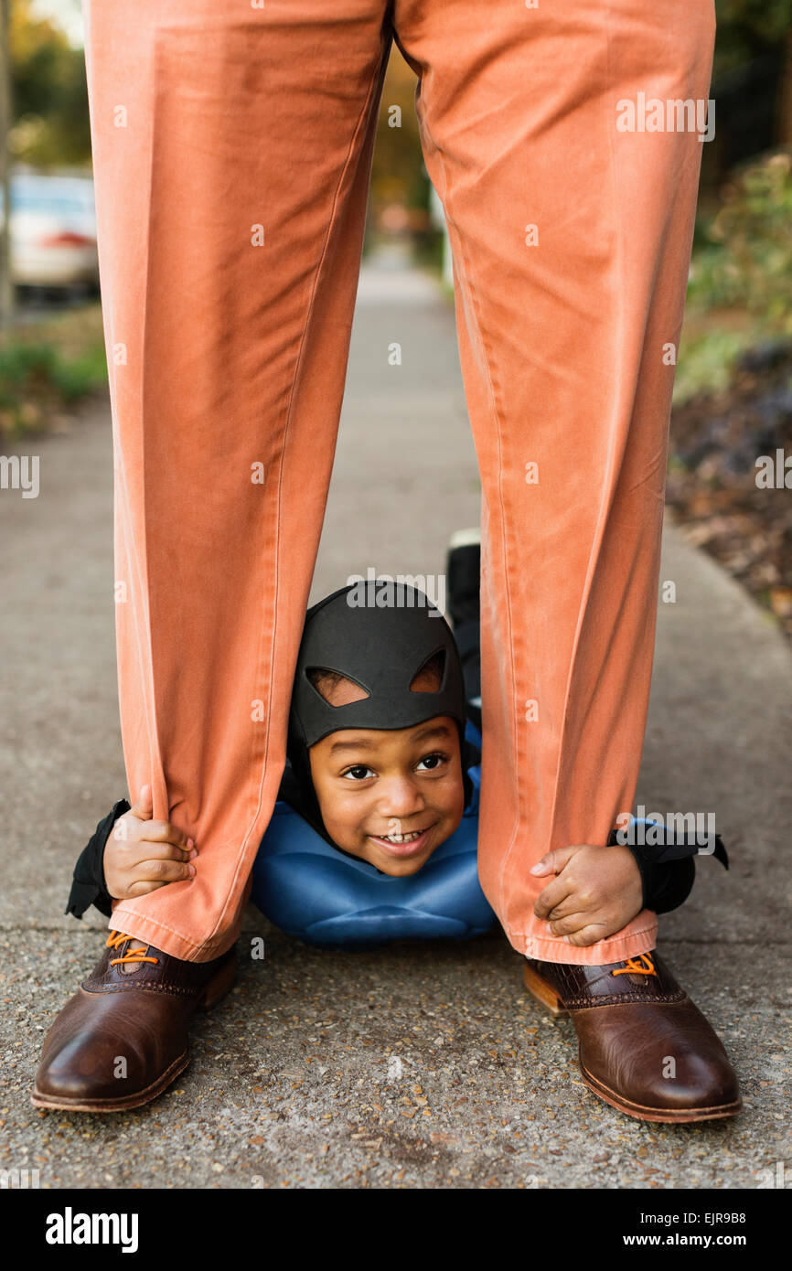 African American boy trick-or-treating with father on Halloween Stock Photo