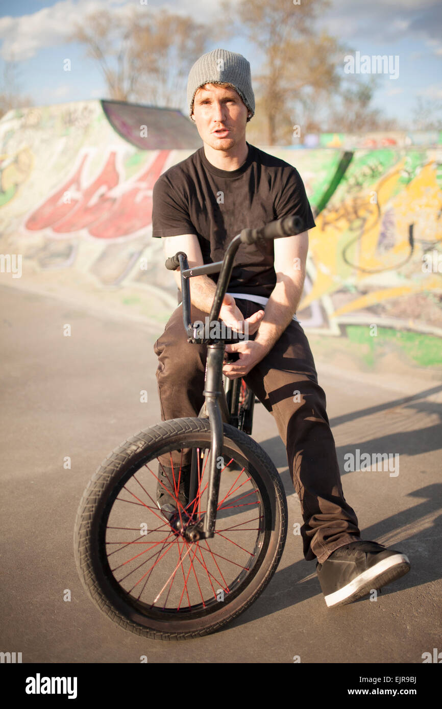 Caucasian man riding BMX bicycle at skate park Stock Photo