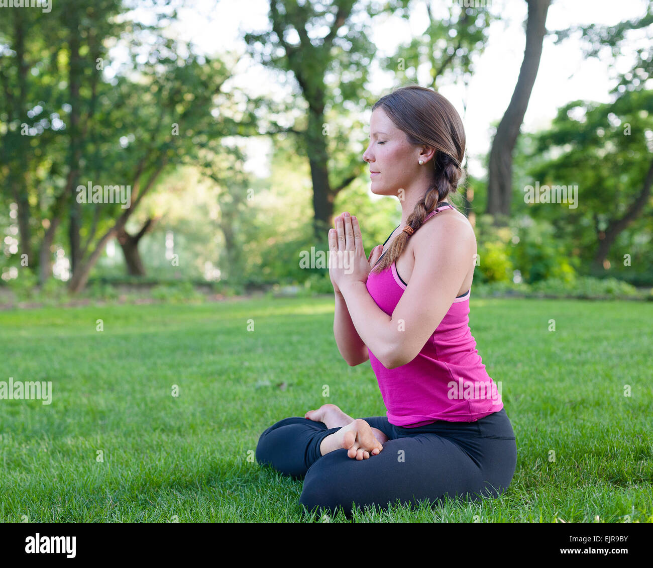 Caucasian woman meditating in park Stock Photo