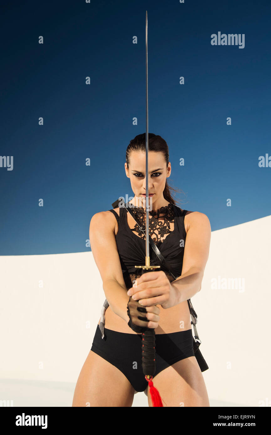 Caucasian woman posing with sword Stock Photo