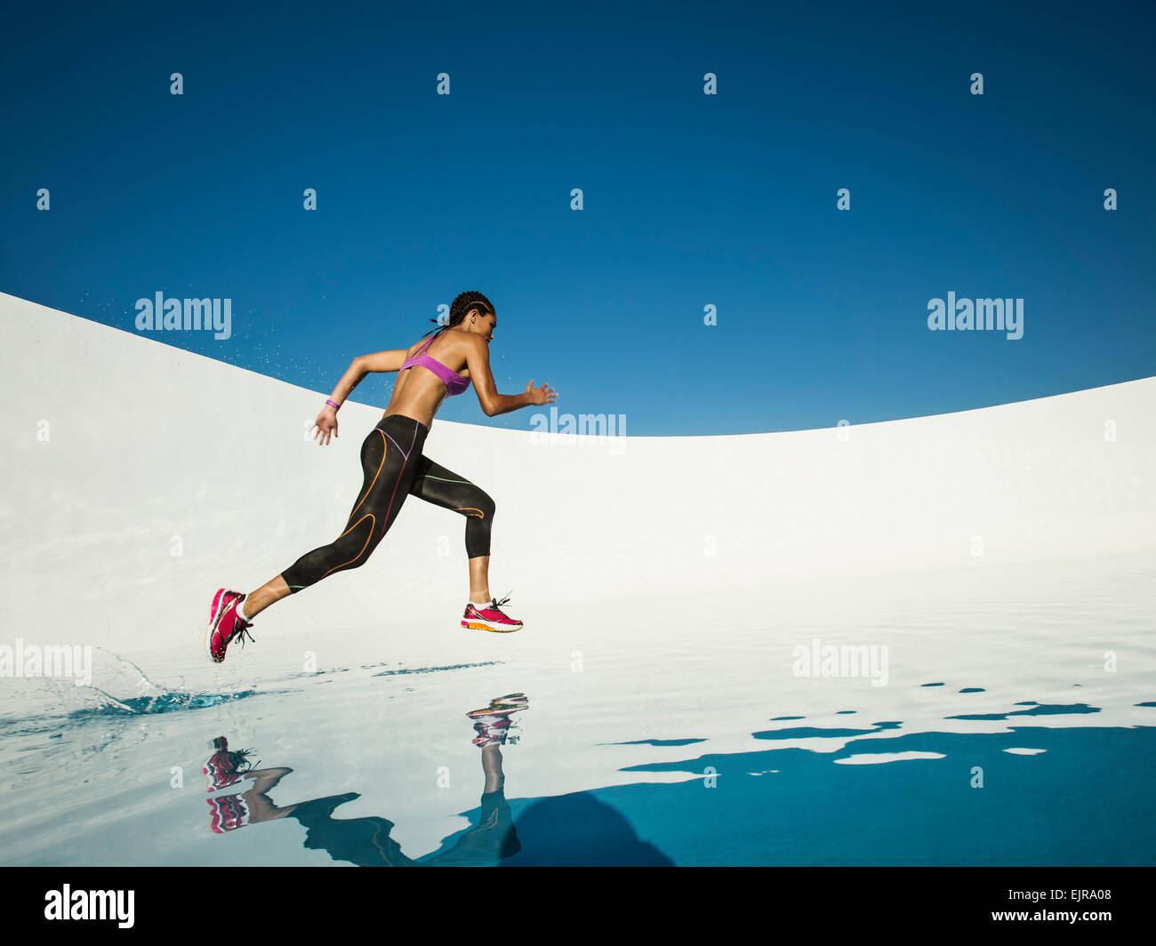 Mixed race woman running on water surface Stock Photo