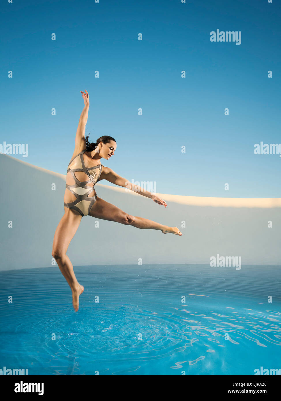 Caucasian woman dancing on swimming pool Stock Photo