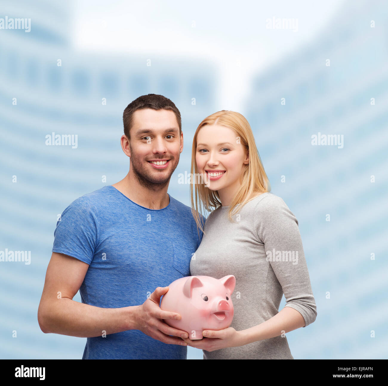 smiling couple holding big piggy bank Stock Photo - Alamy