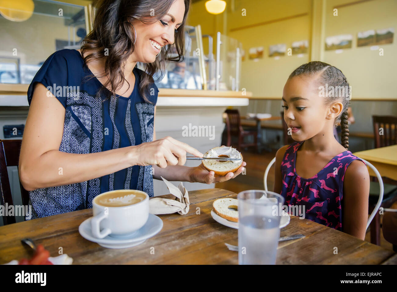 Mother and daughter eating breakfast in cafe Stock Photo