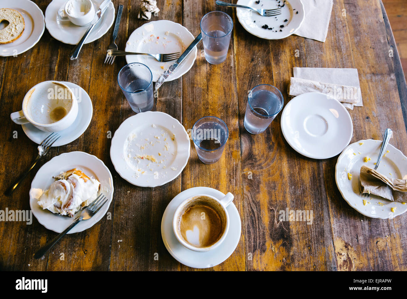 Empty plates, coffee cups and glasses on cafe table Stock Photo