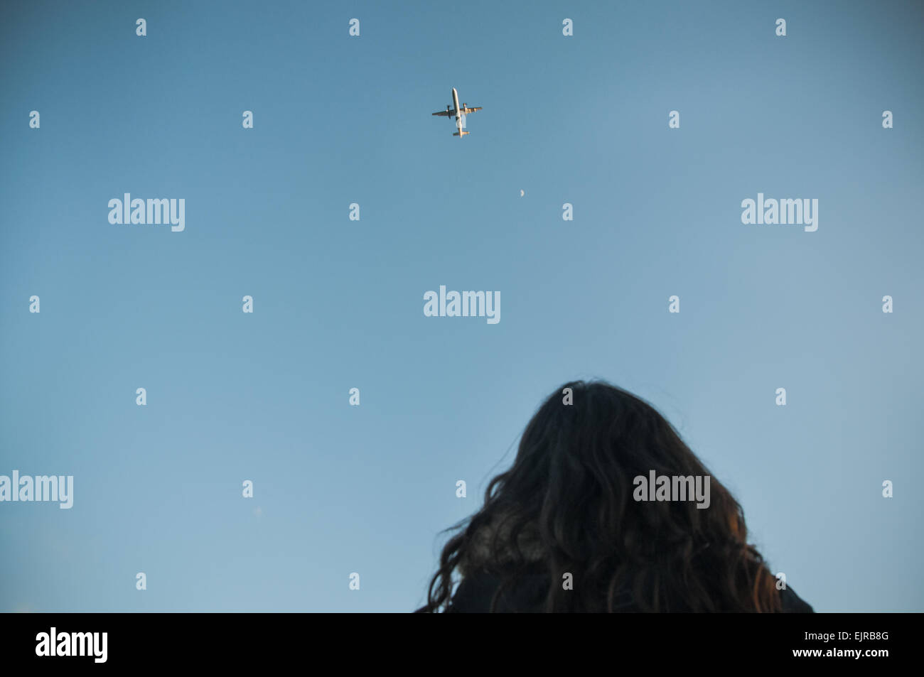 A woman watching a plane flies in the sky Stock Photo - Alamy
