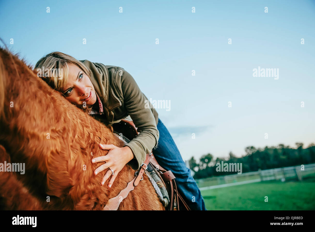 Caucasian woman riding horse on ranch Stock Photo