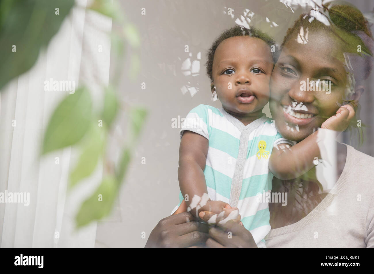 Black mother and son looking out window Stock Photo