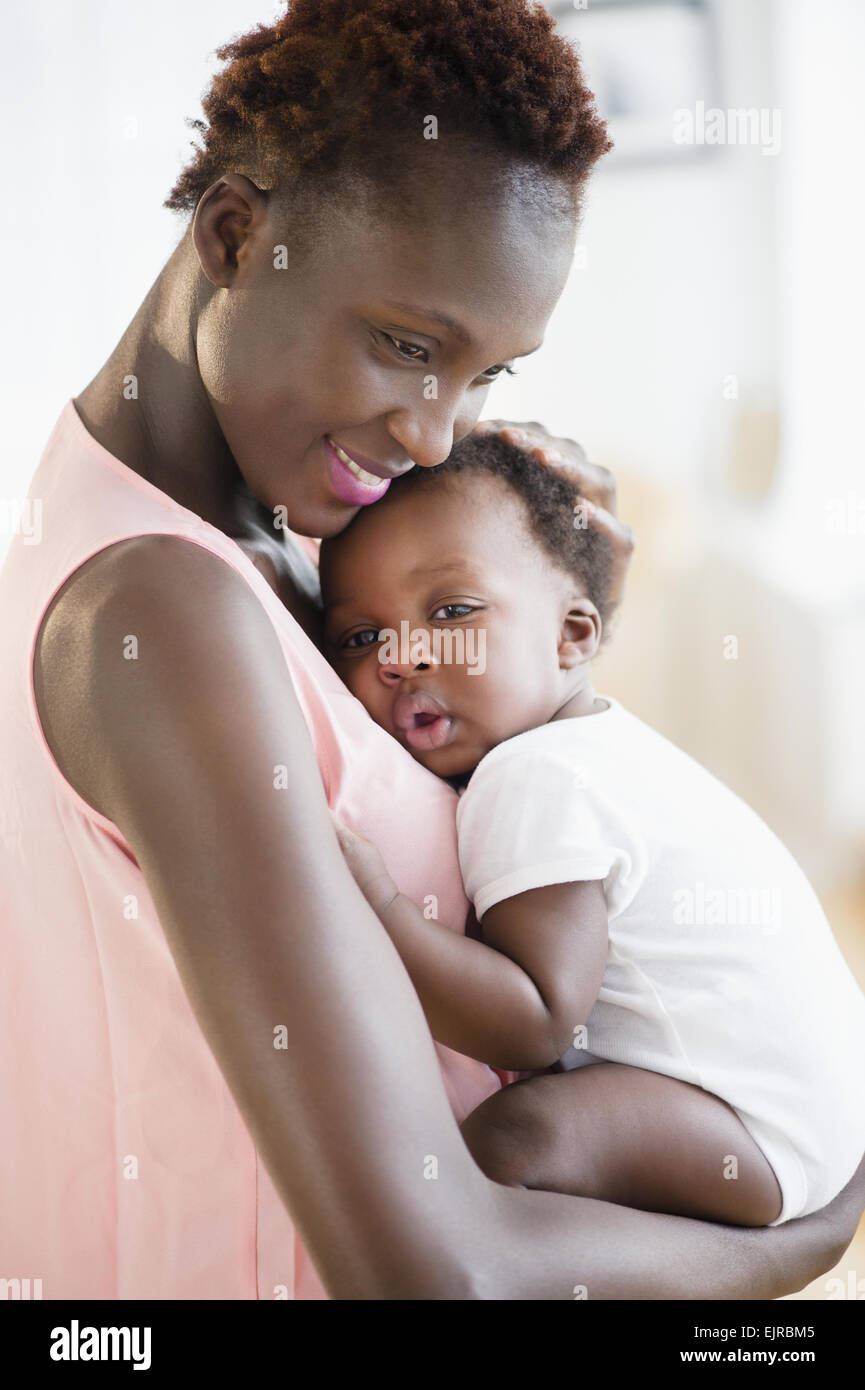 Black mother holding sleepy son Stock Photo