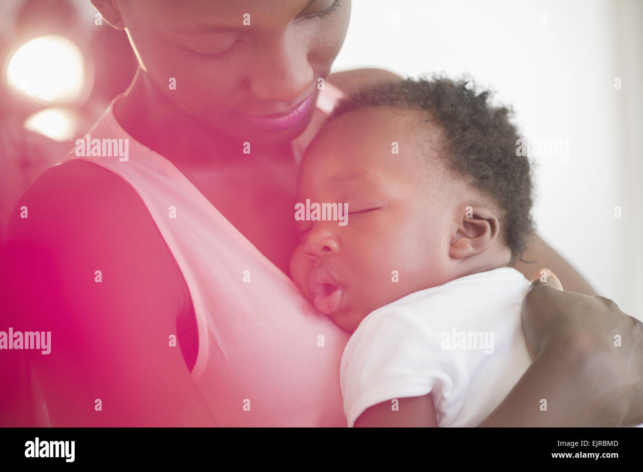 Black mother holding sleeping son Stock Photo