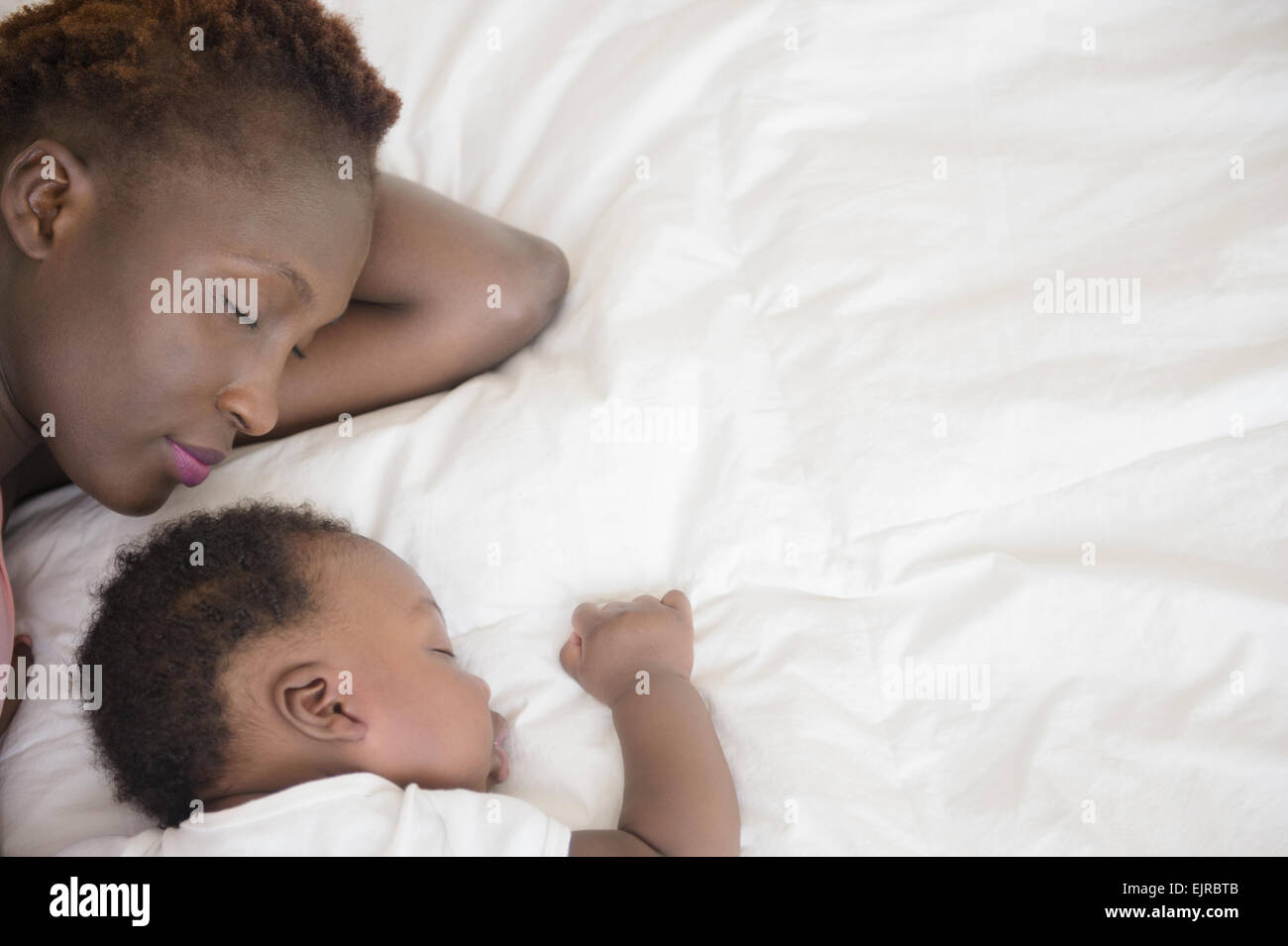 Black mother and son sleeping on bed Stock Photo