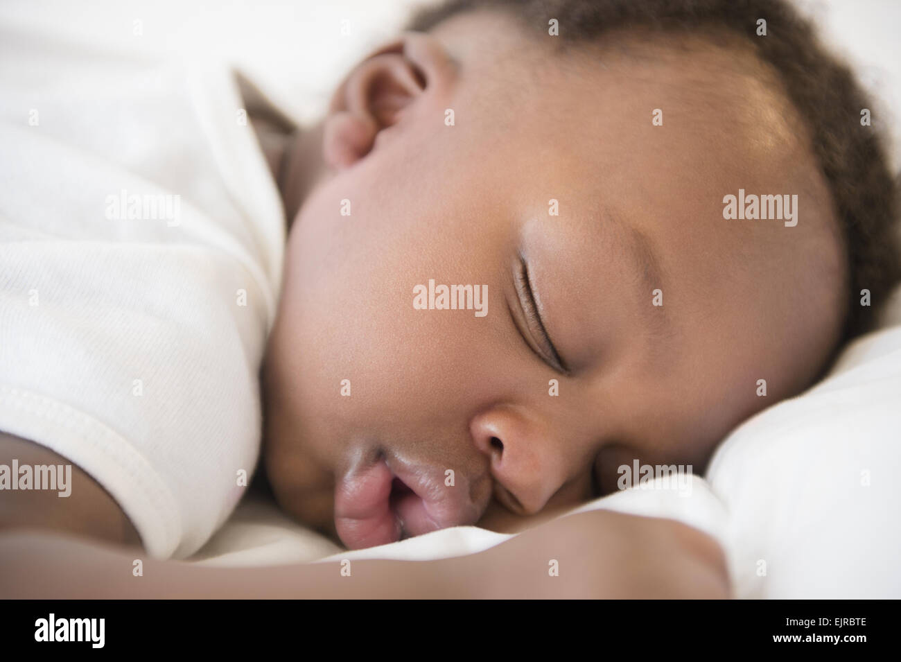 Close up of Black baby boy sleeping on bed Stock Photo
