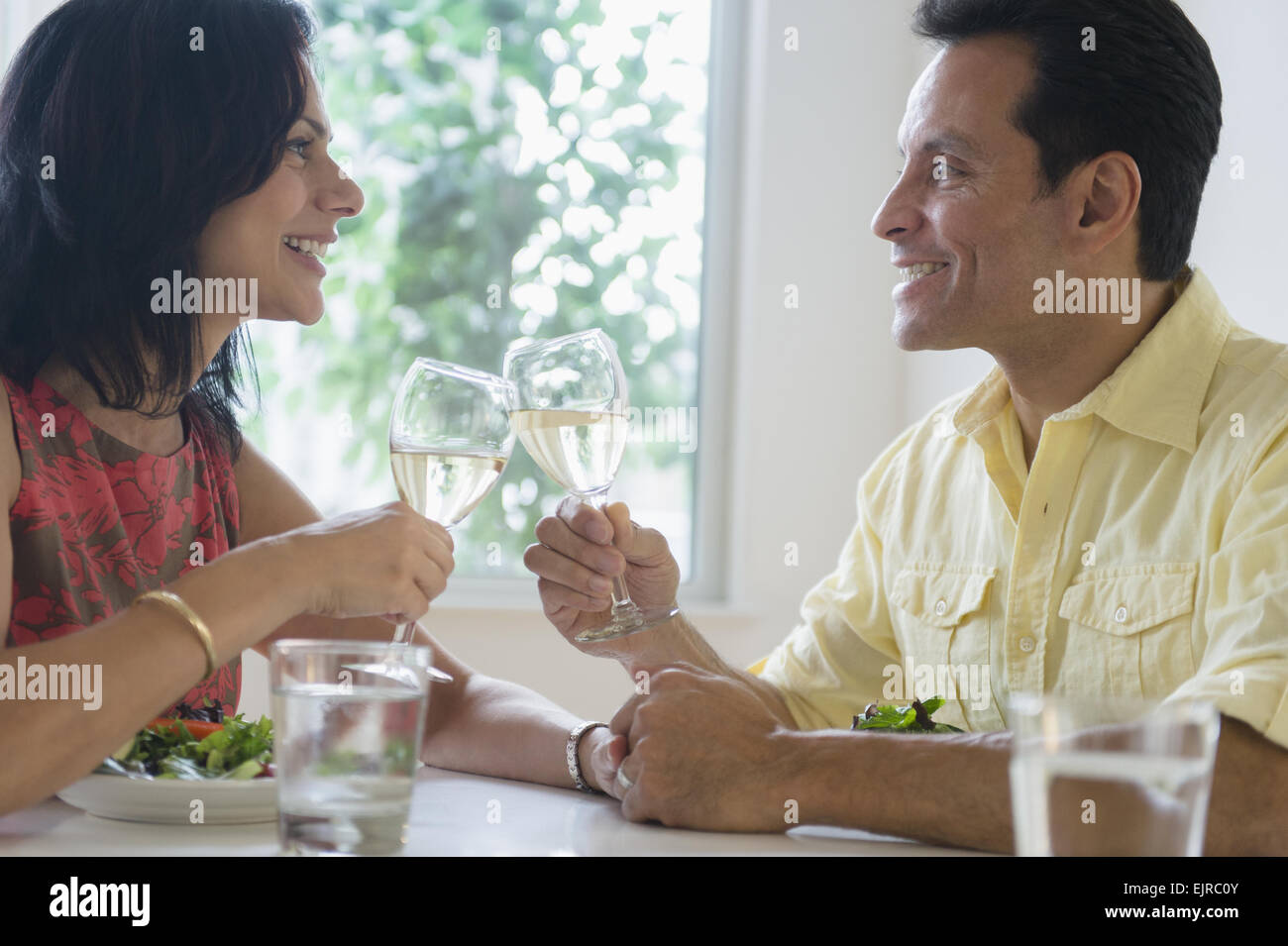 Couple toasting each other with white wine in restaurant Stock Photo