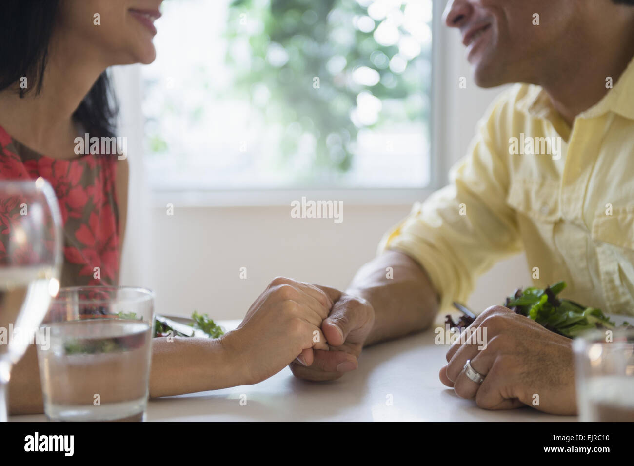 Couple holding hands in restaurant Stock Photo