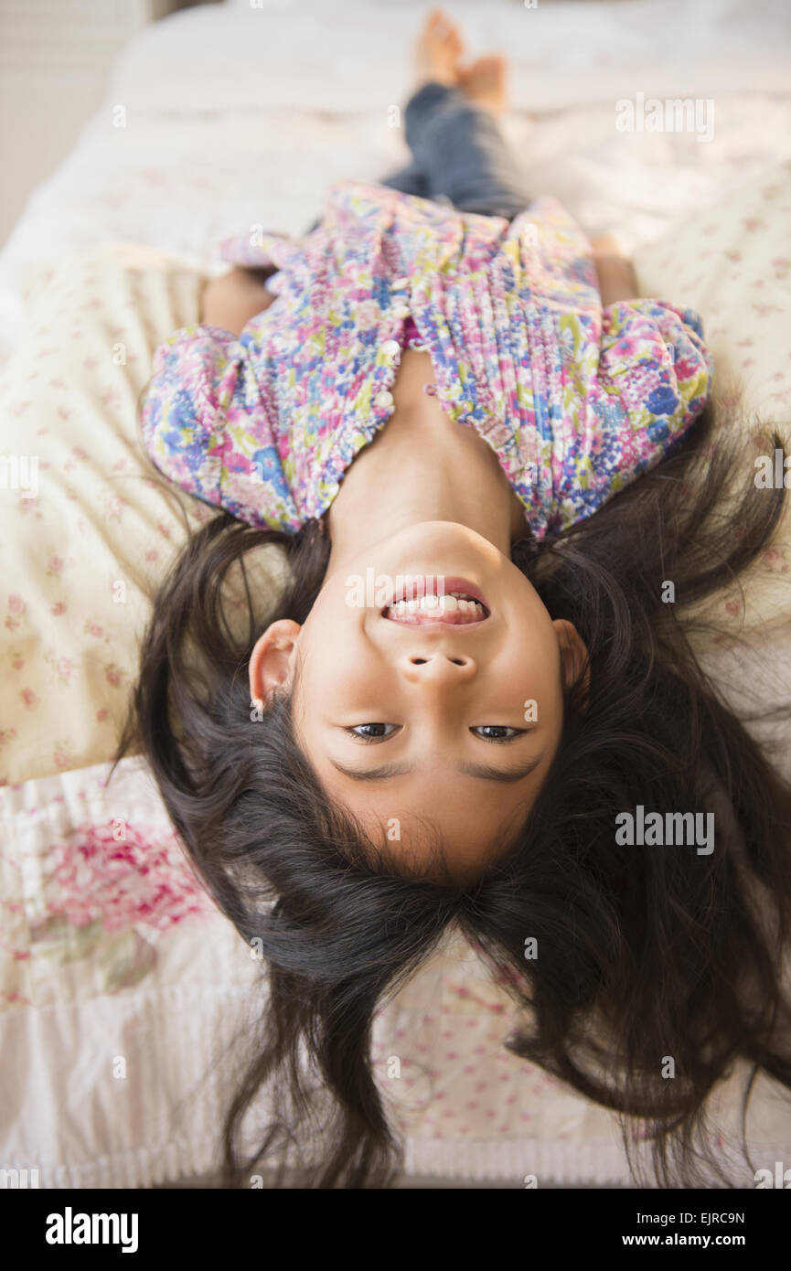 Smiling Vietnamese girl laying on bed Stock Photo Alamy