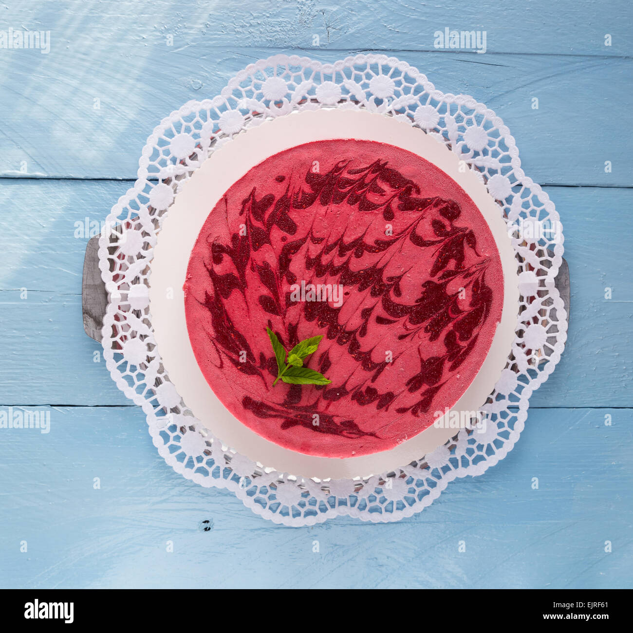 Raspberry ice cream cake on rustic blue wood Stock Photo - Alamy