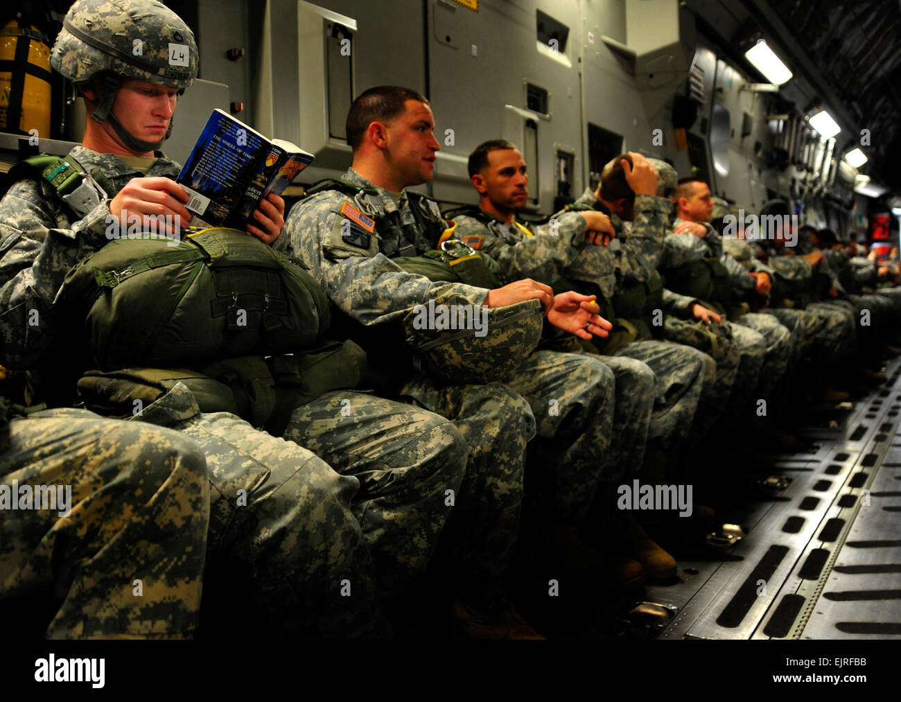 U.S. Army Pfc. Kyle Somerlot, with the 330th Transportation Brigade, reads a book aboard a C-17 Globemaster III cargo aircraft as he awaits his turn to perform an airborne insertion during a joint forcible entry exercise at Pope Air Force Base, N.C., on June 21, 2010.  A joint forcible entry exercise is a weeklong exercise conducted six times a year by soldiers from Fort Bragg and airmen at Pope that is designed to enhance cohesion between the Army and Air Force through large-scale heavy equipment and troop movements.   Staff Sgt. Angelita M. Lawrence, U.S. Air Force. Stock Photo