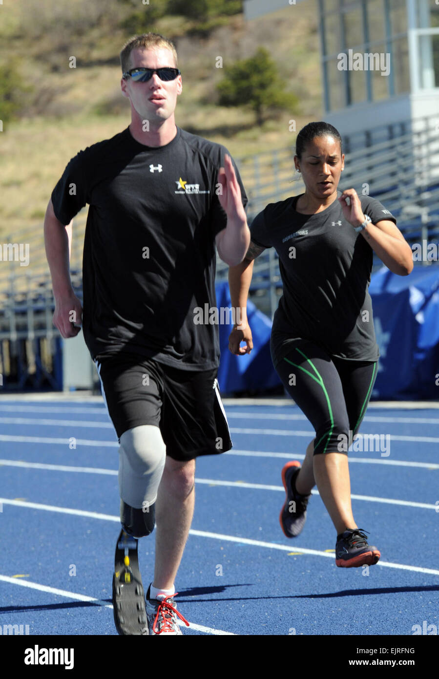 Army Spc. Brynden Keller, 82nd Airborne Division, and 1st Lt. Lacey Hamilton, 323rd Military Intelligence Battalion, round the track during training for the 2012 Warrior Games at the U.S. Air Force Academy in Colorado Springs, Colo., April 23, 2012. Keller, an Indianapolis native, and Hamilton, a Wilmington, Del., native, are two of 44 Army athletes participating in the Track and Field competition at the games. U.S. Army  Sgt. Jennifer Spradlin, 43rd Public Affairs Detachment Stock Photo