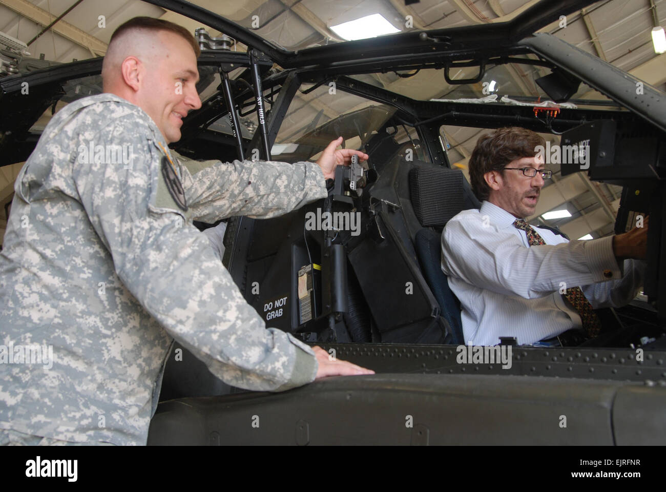 Sgt. 1st Class Ron Bolinsky, left committee chief in charge of Initial Entry Training students, 128th Aviation Brigade, Fort Eustis, Va., explains how to operate an AH-64D Apache Longbow helicopter at Felker Army Airfield to Trent Di Giulio of Dallas and member of the Defense Orientation Conference Association, during the DOCA's visit to Training and Doctrine Command the afternoon of July 30 at Fort Eustis, Va. U.S. Army  Sgt. 1st Class Kelly Jo Bridgwater, Training and Doctrine Command Public Affairs Stock Photo
