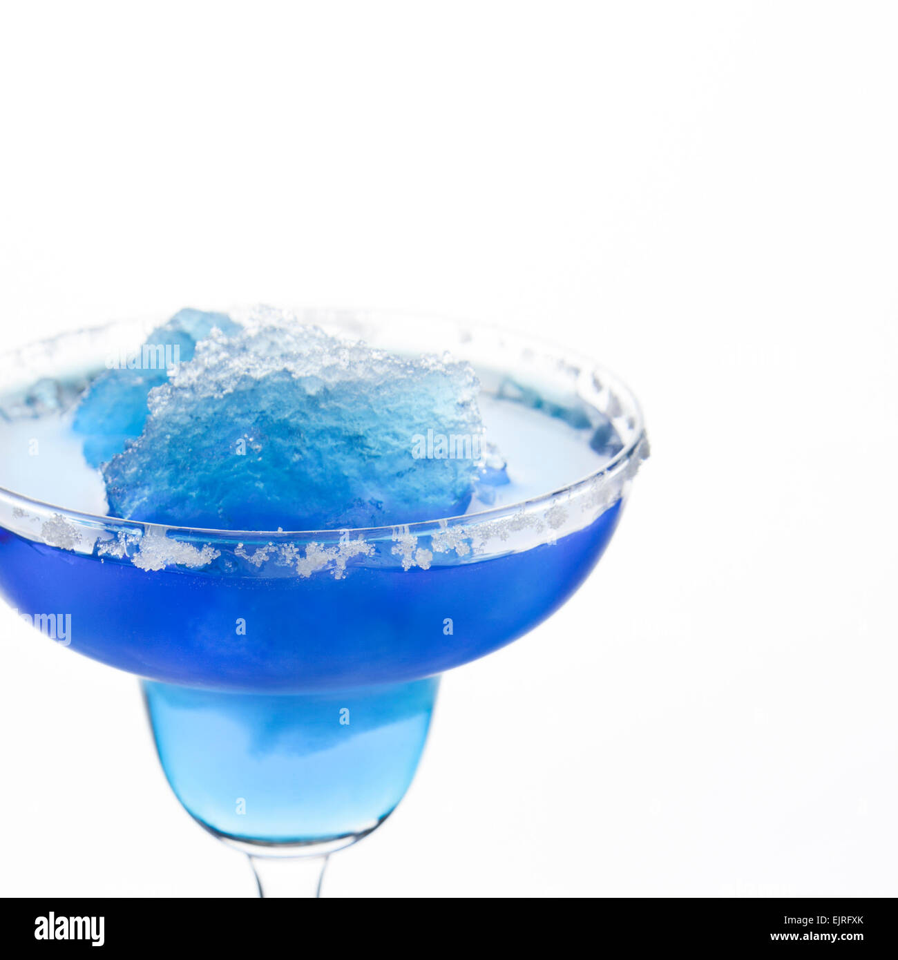 A margarita glass is filled with a blue frozen margarita; white sugar coats the rim; white background; square format Stock Photo