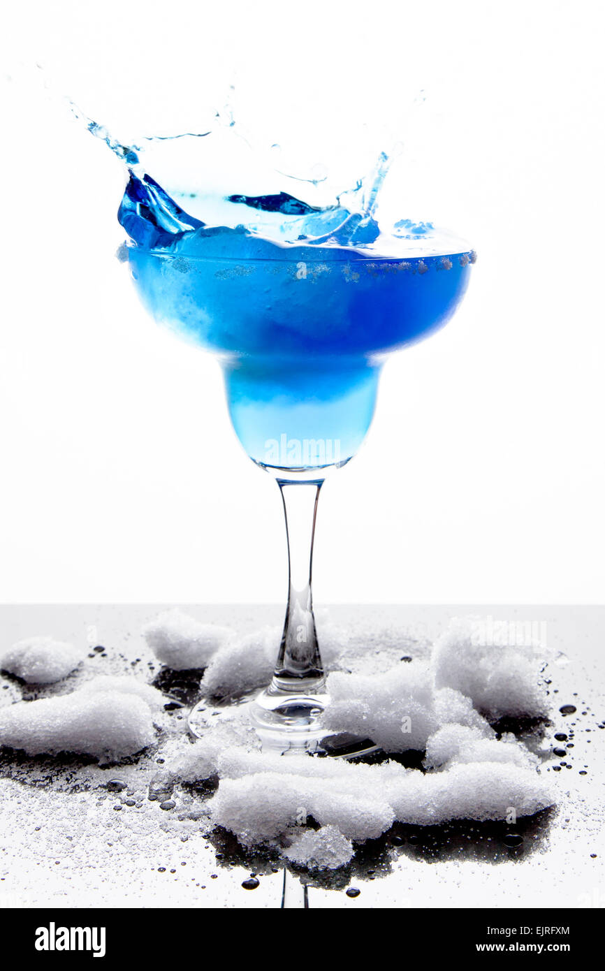A margarita glass is filled with a blue frozen margarita; white sugar