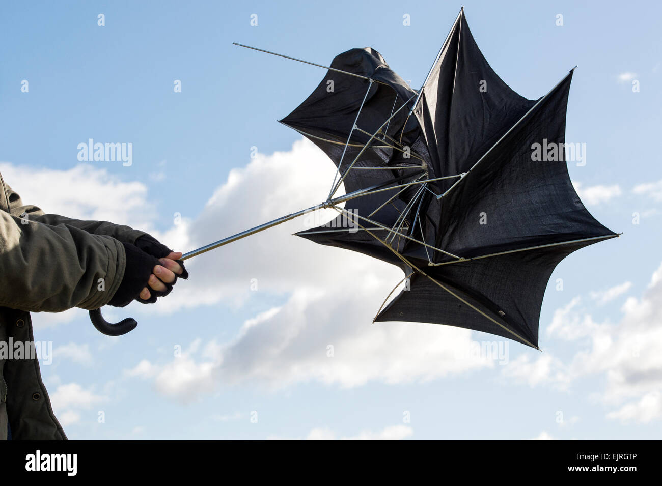 Man holding an umbrella in gale force winds Stock Photo