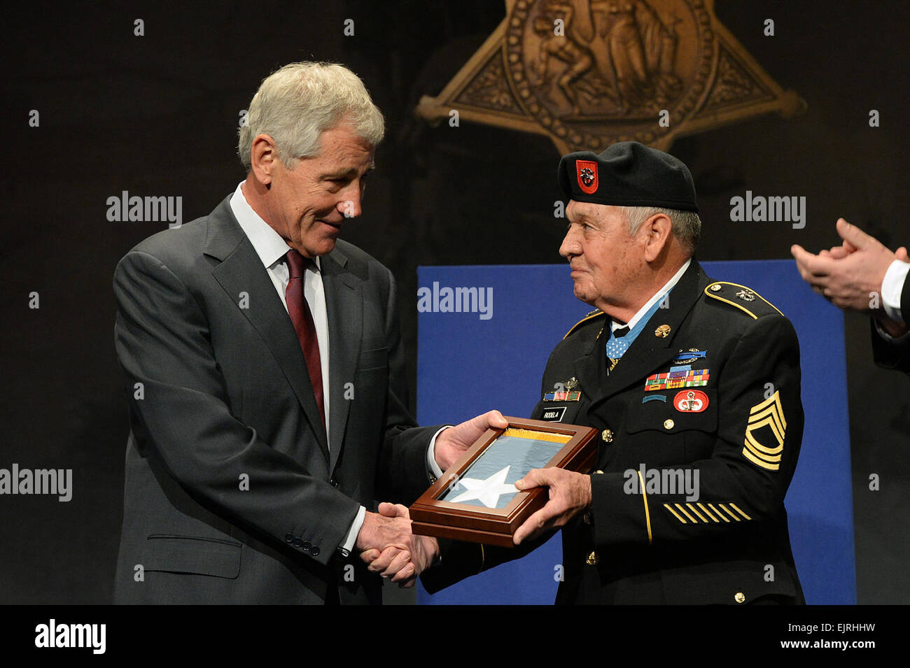 Sgt.1st Class Jose Rodela is presented the Medal of Honor Flag by Secretary of Defense Chuck Hagel after being inducted into the Hall of Heroes during a ceremony at the Pentagon, Washington D.C., March 19, 2014. Rodela distinguished himself for his valorous actions on Sept. 1, 1969, while serving as the company commander in Phuoc Long Province, Vietnam.  Mr. Leroy Council Stock Photo