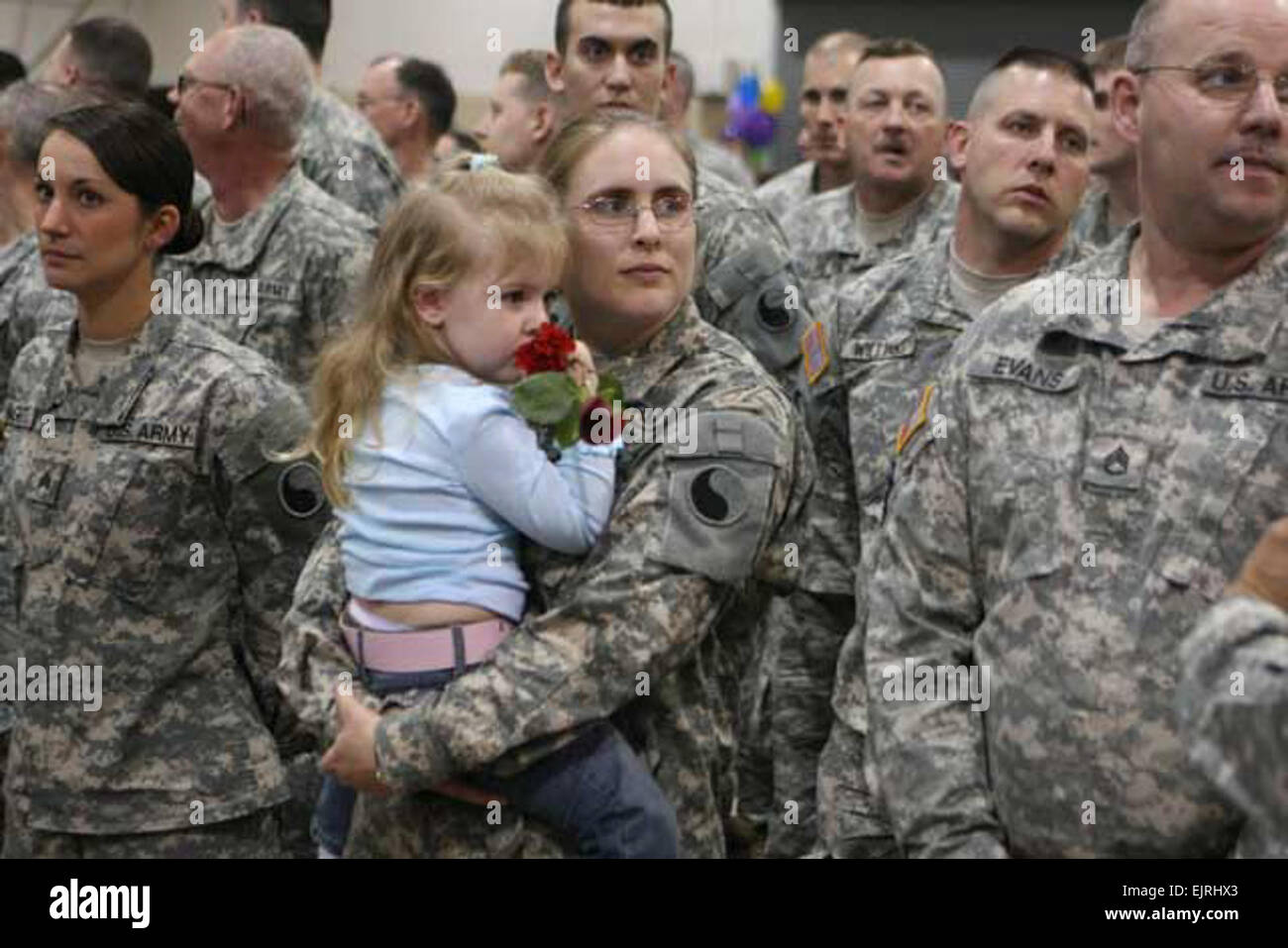 Sgt. Christina Phillips, a human resources specialist from Staunton, Va., waits with her daughter Jasmine for the start of the formal welcome home ceremony for Headquarters, 116th Infantry Brigade Combat Team of the Virginia National Guard. The unit returned home to Staunton after serving eight months in Iraq.  Maj. Cotton Puryear, Virginia Guard Public Affairs Stock Photo