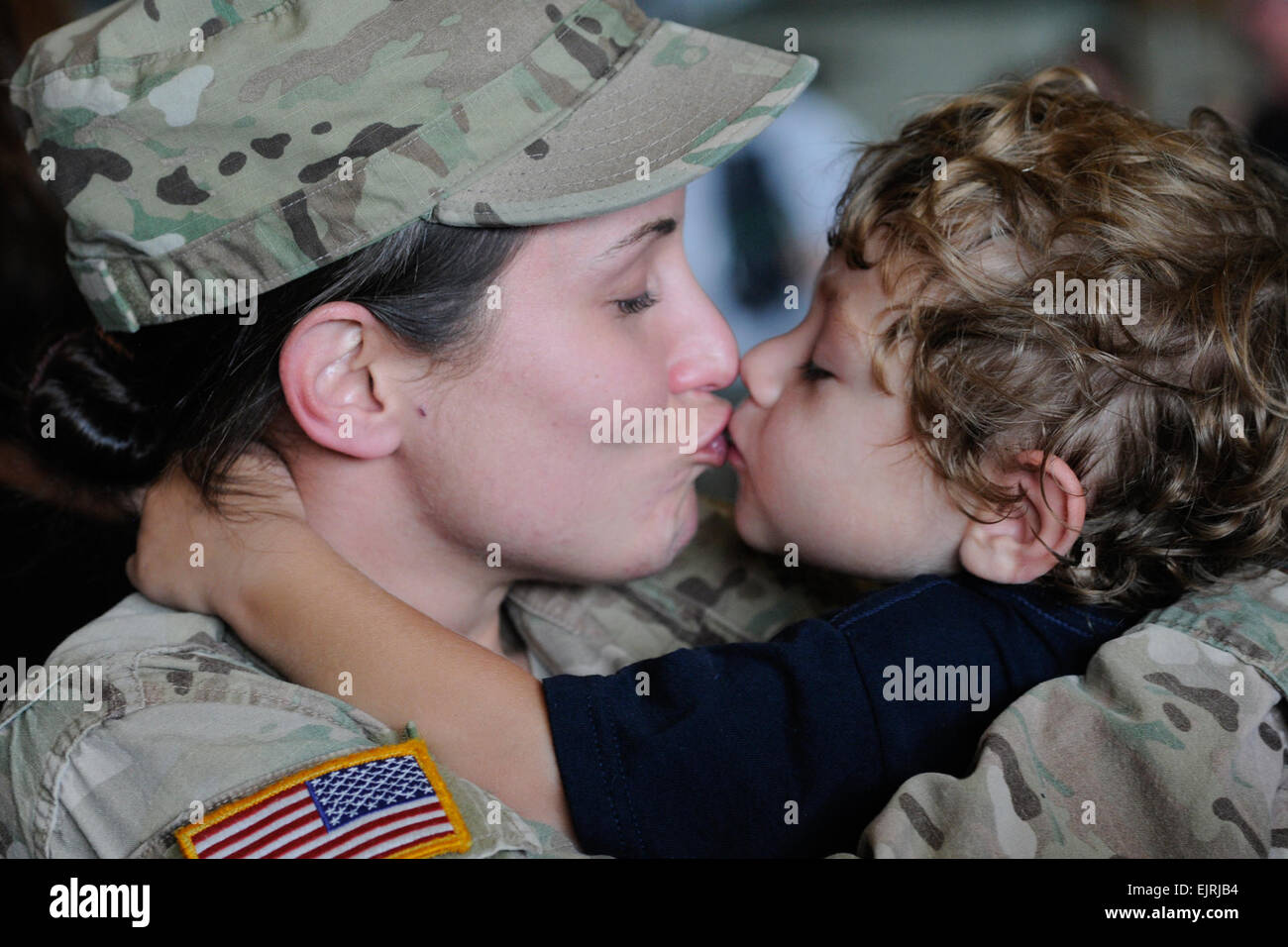 Spc. Sabrina Day, 132nd Military Police Company, South Carolina National Guard, smothers her three-year-old son, Blake with hugs and kisses Aug. 4, 2014, at Eagle Aviation in Columbia, S.C. upon returning from deployment to Afghanistan. More than 250 family and friends awaited the arrival of the approximately 73 Soldiers who returned from the six-month deployment.  U.S. Army National Guard photo by Sgt. Brad Mincey Stock Photo