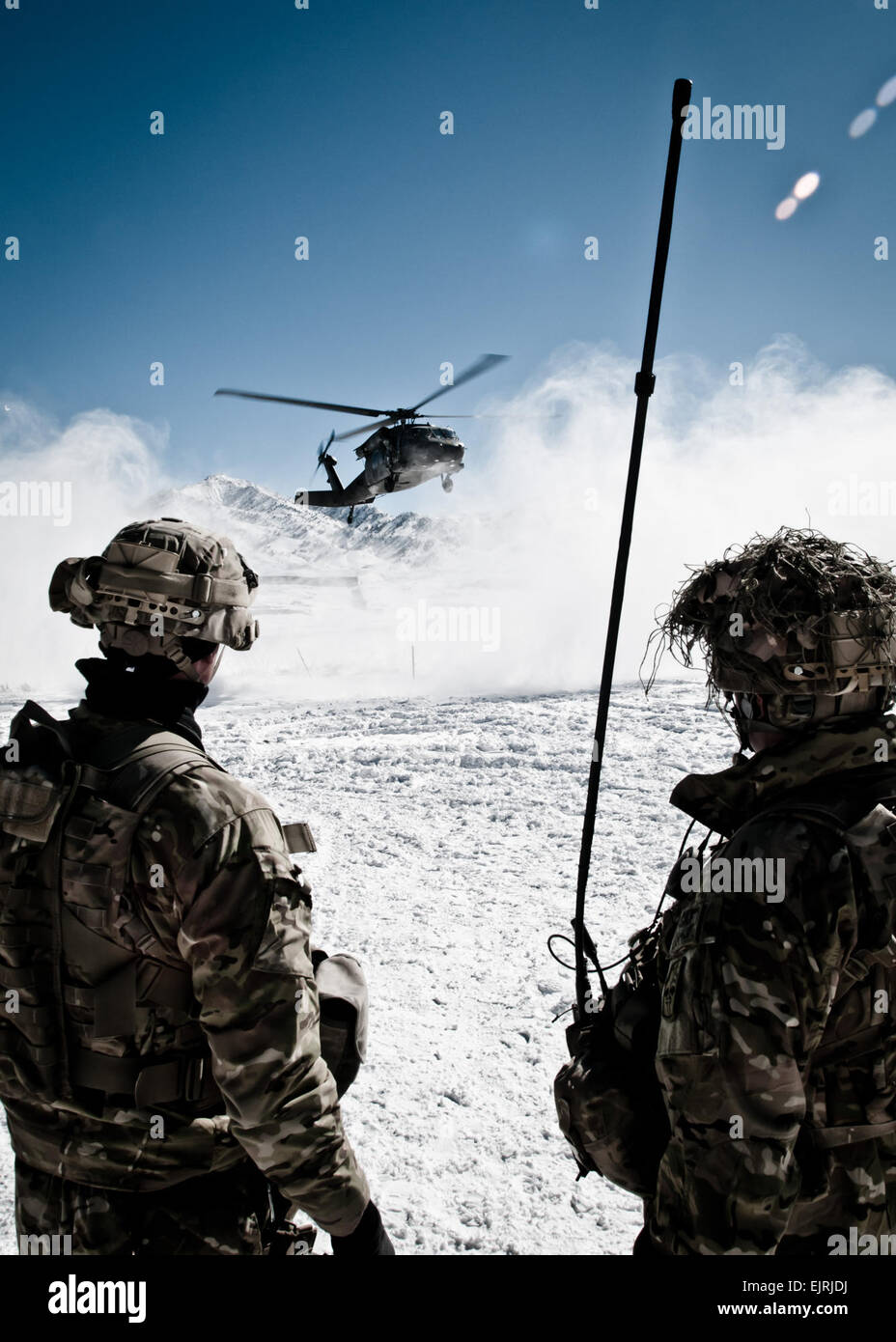 U.S. Army Staff Sgts. Neil Nunez and Justin Puchalsky, from Company A, 2nd Battalion, 28th Infantry Regiment, Task Force 3-66, watch the arrival of a helicopter at their remote combat outpost in Marzak. Marzak has been a haven for insurgent fighters over the past decade. A new police checkpoint is being constructed through the winter in Marzak to disrupt the movement of insurgent forces through the area, located just 6 km from the site of the Battle of Takur Ghar. Stock Photo