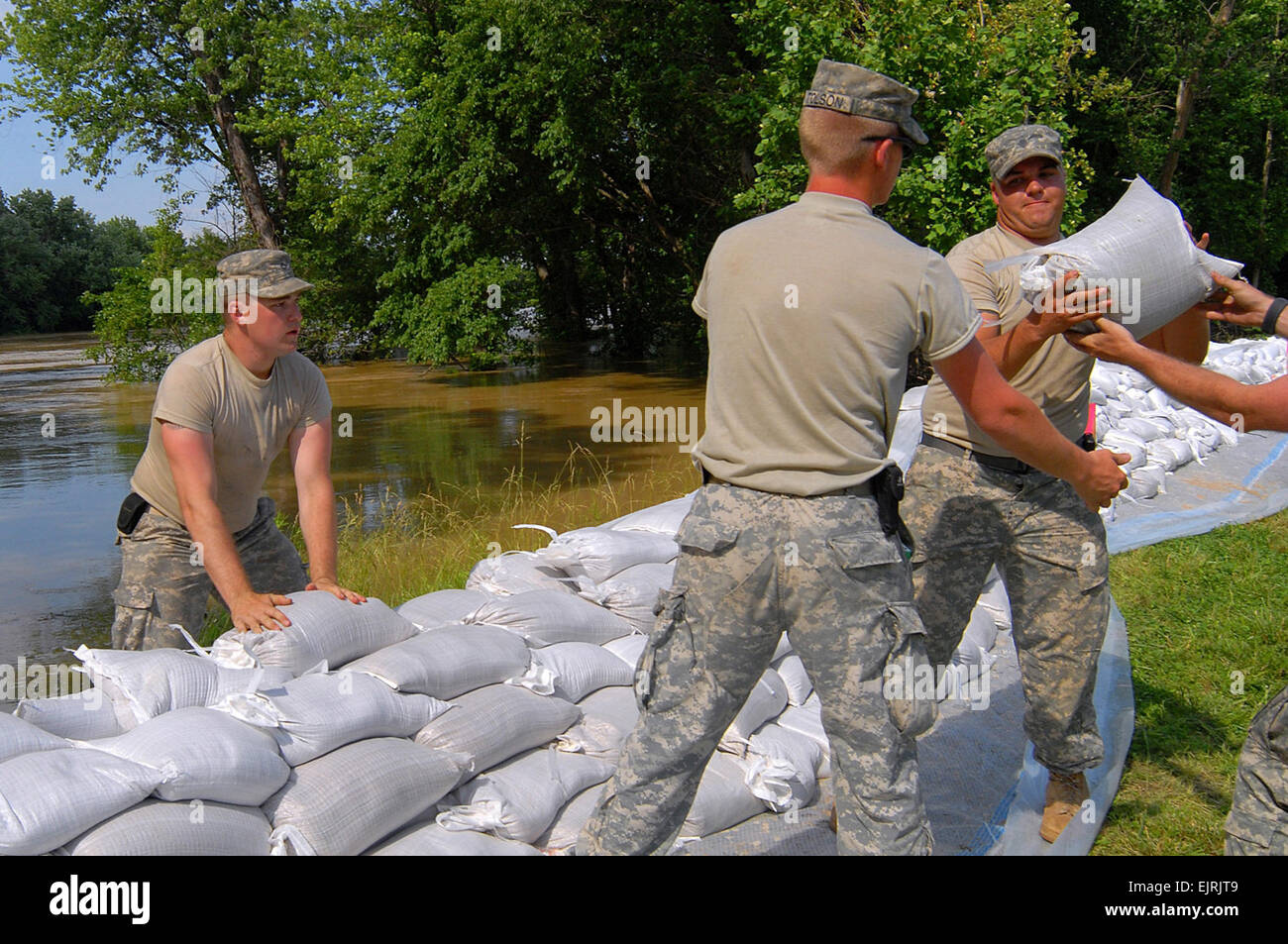 Soldiers Battle Fire and Water  Air Force Staff Sgt. Justin Goeden June 16, 2008  Soldiers from the 1613th Engineer Support Company pile sandbags in Hazleton, Ind., on June 12, 2008. Thousands of bags were laid to raise the height of the levee to prevent the river from breaching and spilling into town. Stock Photo