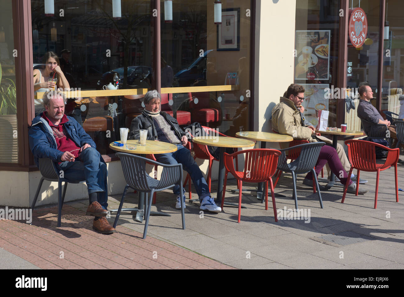 People sitting outside Costa coffee shop in spring sunshine, Bristol