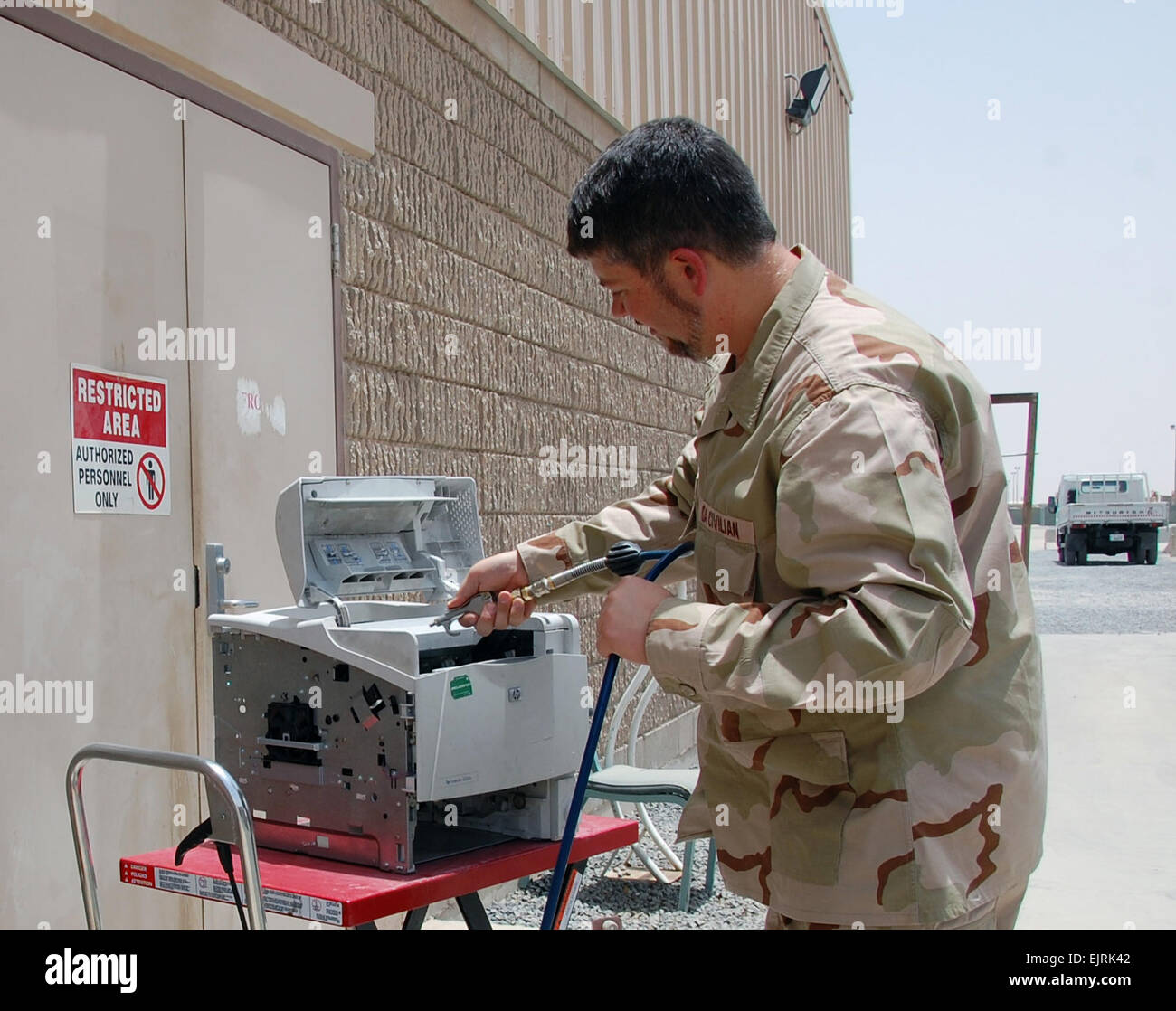 Computer technician Martin Barnoski, a deployed Department of the Army civilian, uses compressed air to clean a computer printer, June 24, 2008, at Camp Arifjan, Kuwait.  Barnoski is a member of the U.S. Army Communications-Electronics Command Life Cycle Management Command Forward Repair Activity in Kuwait. Known as the &quot;Tobyhanna FRA,&quot; the volunteer team from Tobyhanna Army Depot, Pa., provides maintenance support to units across Southwest Asia by servicing computers and associated peripheral devices. The FRA staff has serviced and repaired nearly 3,200 items this year.   Jim Hinnan Stock Photo