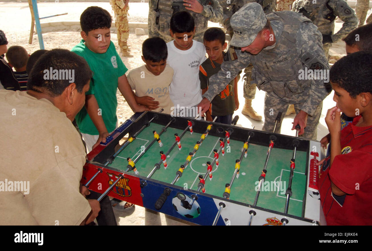 Gen. David Petraeus, Multi-National Force – Iraq commander, plays foosball with Iraq children during his visit to Nassir Wa Salam, west of Baghdad, Aug. 2, 2008. Stock Photo
