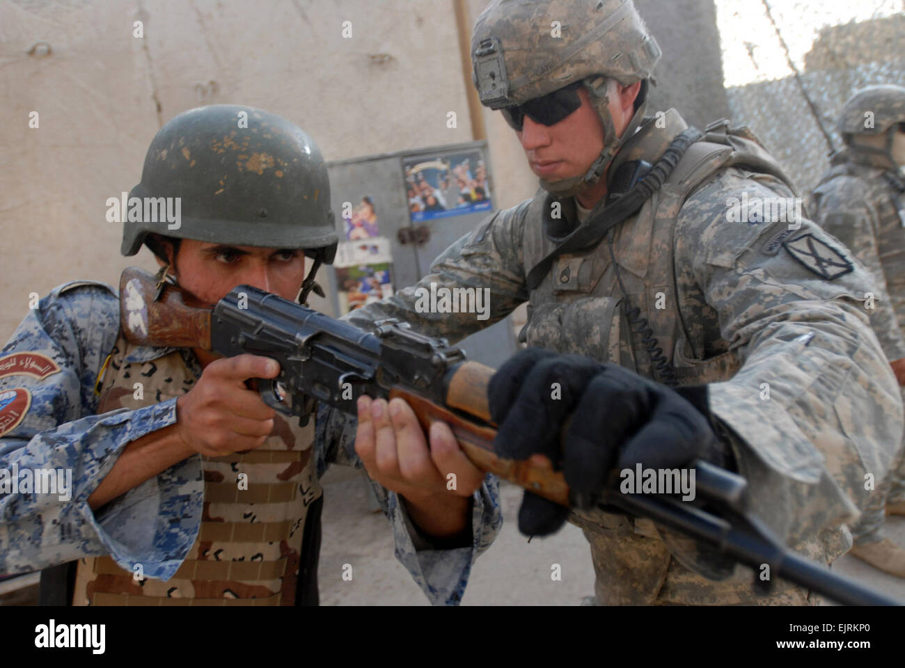 Staff Sgt. Nathan Camp, a squad leader with the 3rd Platoon, Company C, 2nd Battalion, 4th Infantry Regiment, directs an Iraqi national policeman's rifle to cover his sector of fire during room clearance training, Aug. 14, 2008, in the Jaza'ir community of southern Baghdad. Camp, who hails from Paxton, Ill., is attached to the 1st Brigade Combat Team, 4th Infantry Division, Multi-National Division - Baghdad, in support of Operation Iraqi Freedom. Stock Photo