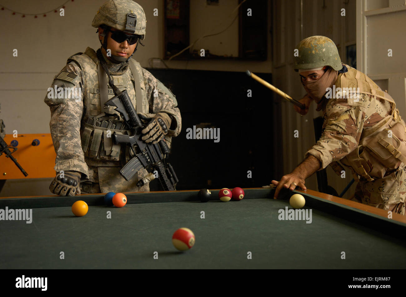 2nd Lt. Critchfield, 1st Platoon, Comanche Company, 2nd Battalion, 8th Infantry Regiment, 4th Infantry Division, Fort Carson, Colo. and a soldier from the 8th division Iraqi army shoot a game of pool at a local arcade while conducting a joint dismounted patrol Oct. 10, 2008 in Ad Diwaniyah, Iraq. Stock Photo