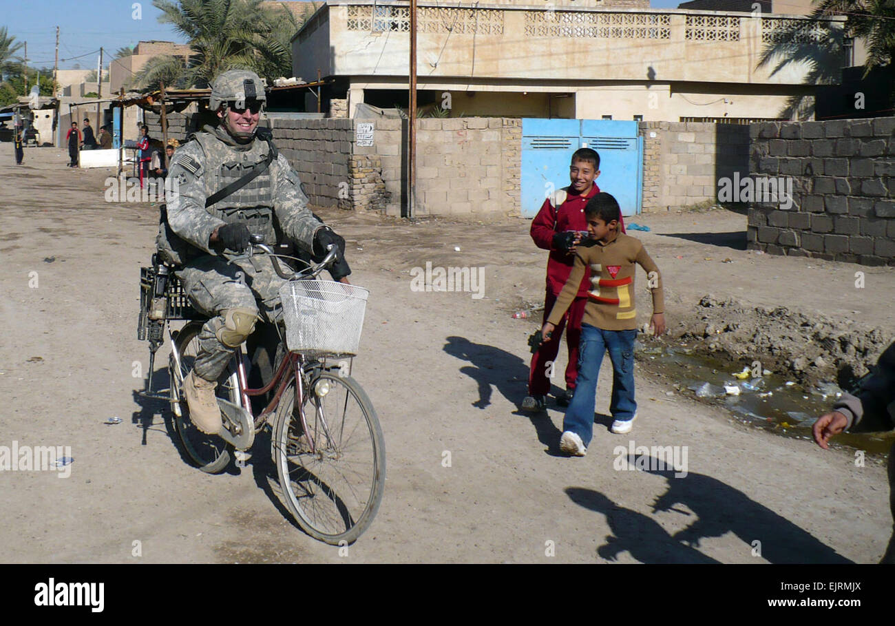 Sgt. 1st Class Waylon Petty, a San Antonio native, rides a bicycle through the streets of the South Karnabot neighborhood of the Abu Ghraib province, west of Baghdad, during a joint patrol with the Iraqi army, Dec. 8. Multi-National Division – Baghdad Soldiers continue to increase relationships with the locals while providing security and comfort during joint patrols with the Iraqi army in the Abu Ghraib province. Petty serves as an infantryman assigned to Company B, 1st Battalion, 21st Infantry Regiment “Gimlets,” 2nd Stryker Brigade Combat Team “Warrior,” 25th Infantry Division. Stock Photo
