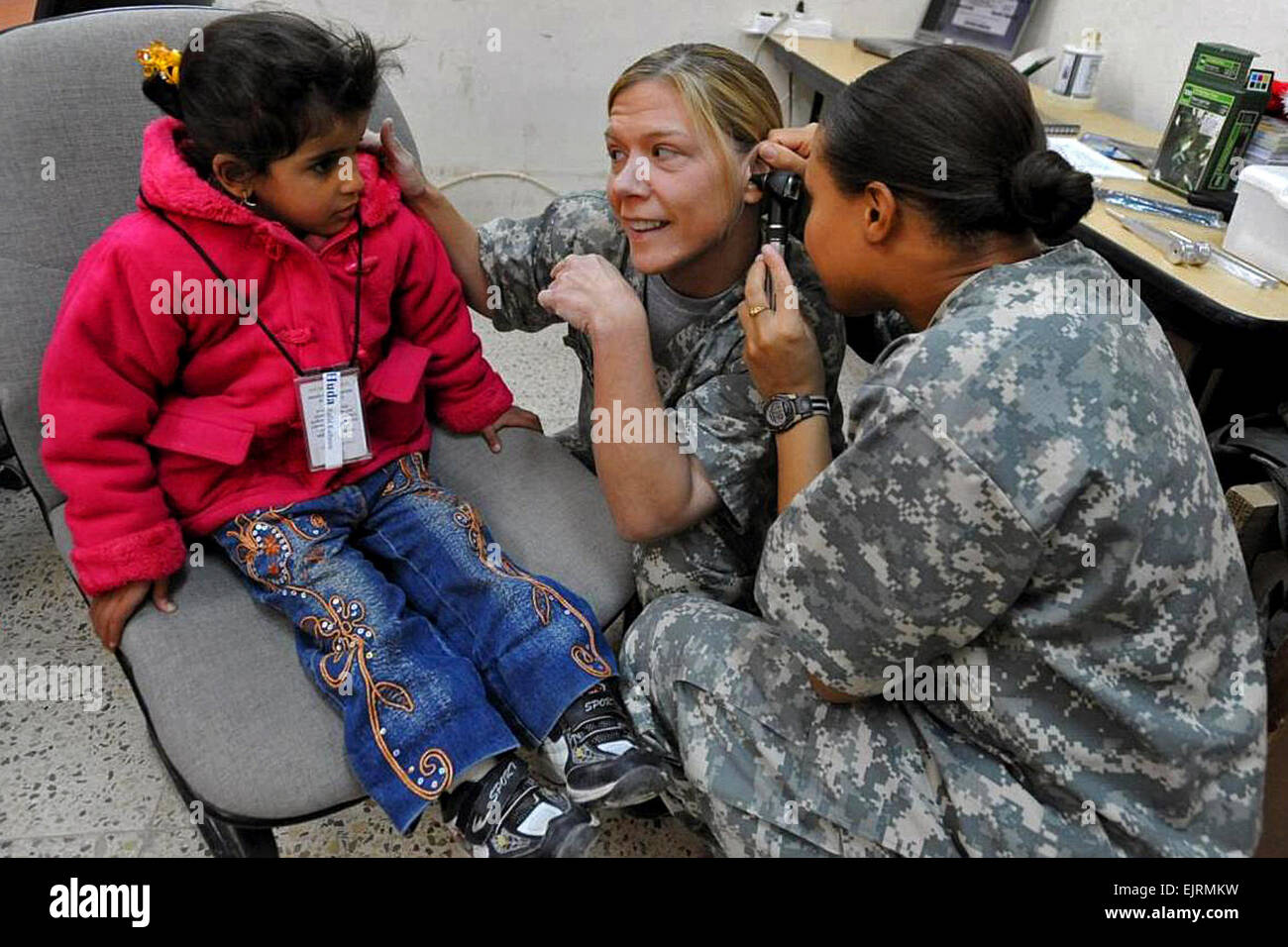 Capt. Lori August and Capt. Ramona Toussant show a hearing-impaired Iraqi girl from Rumaythuh, Iraq, how they administer a hearing examination, Dec. 11, 2008. The Iraqi girl is visiting Combat Operations Base Adder in Tallil, Iraq, to be tested for a hearing aid. August and Toussant are assigned to the 1st Cavalry Division's Company C, 27th Brigade Support Battalion, 4th Brigade Combat Team.   Staff Sgt. Brendan Stephens Stock Photo
