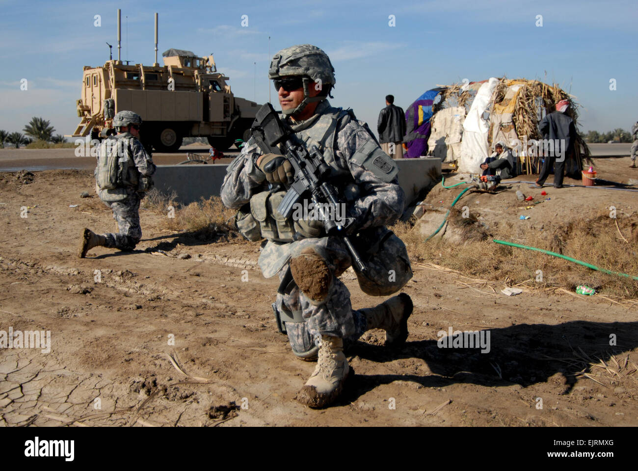 U.S. Army Cpl. Oscar Tovar from Headquarters and Headquarters Company, Charlie Company, 1st Battalion, 2nd Infantry Regiment, 172 Infantry Brigade takes a knee while sweeping Main Supply Route Tampa for improvised explosive devices as part of an un-mounted route clearance, outside of Forward Operating Base Kalsu, Iraq on Jan 3, 2009. Stock Photo